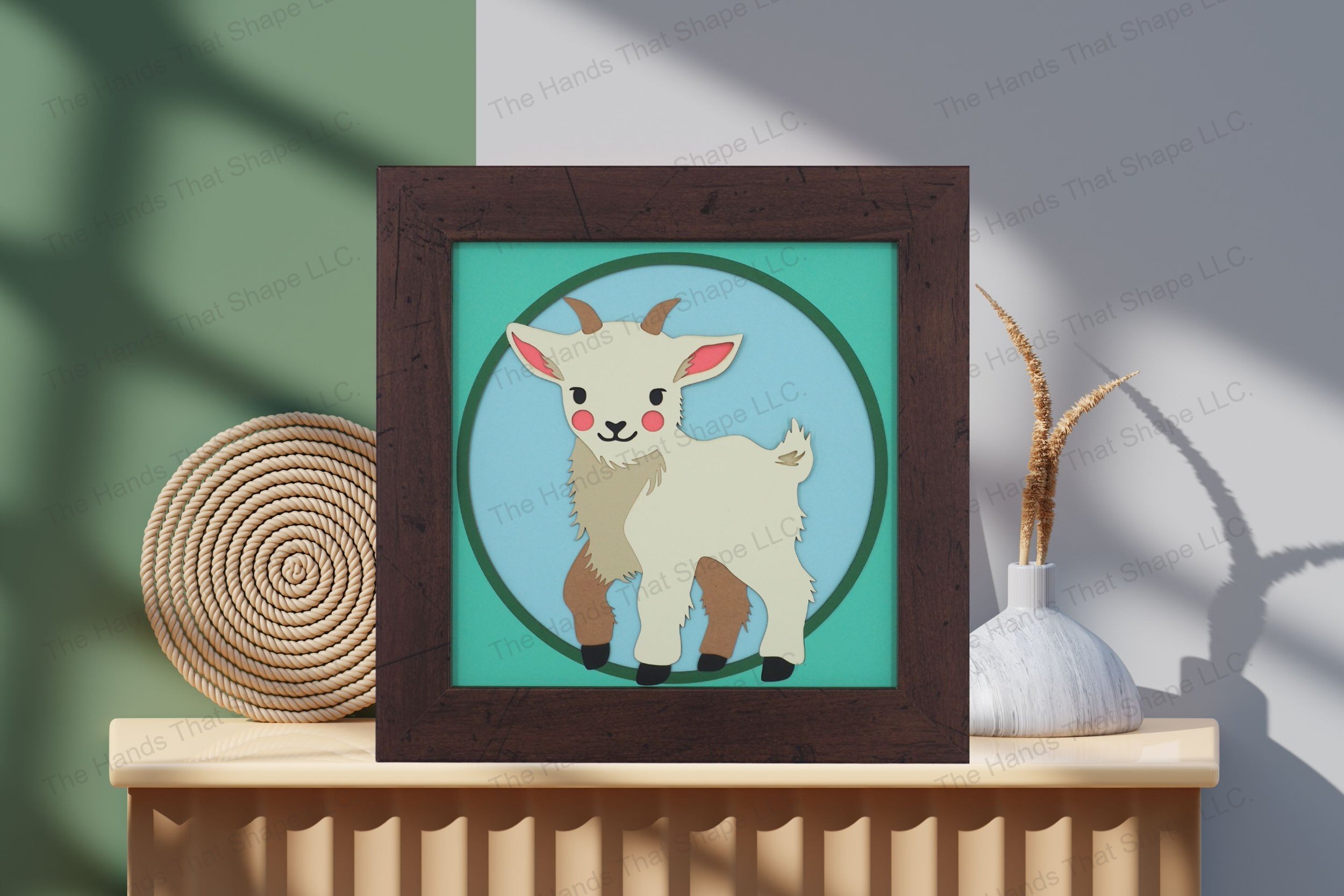 Admire this baby goat-themed cardstock artwork, displayed on a table, showcasing its vibrant layers and capturing the innocent appeal of a young farm animal.