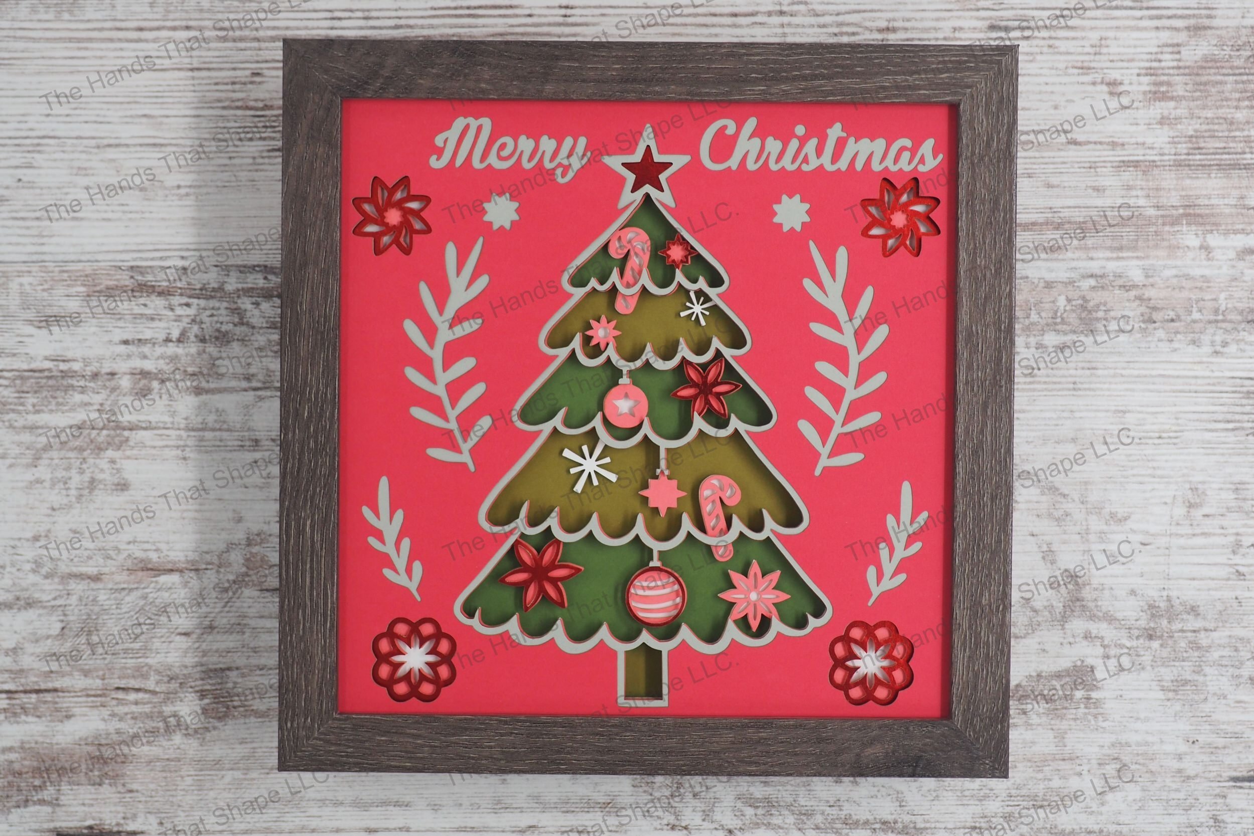 A festive layered paper shadowbox featuring a richly decorated Christmas tree with ornaments and a star topper, accompanied by the greeting 'Merry Christmas.'