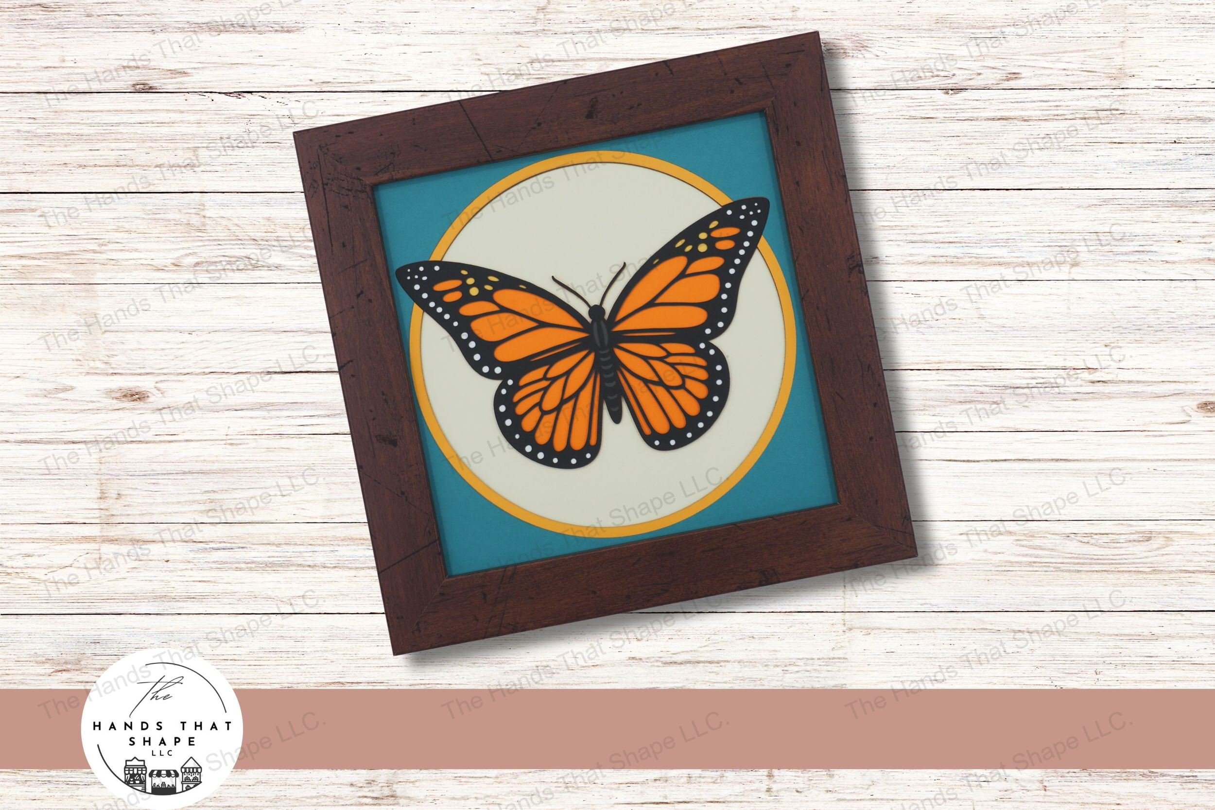 This layered cardstock art piece captures the detail of a Monarch butterfly's fully spread wings, showcasing vibrant colors and intricate patterns.