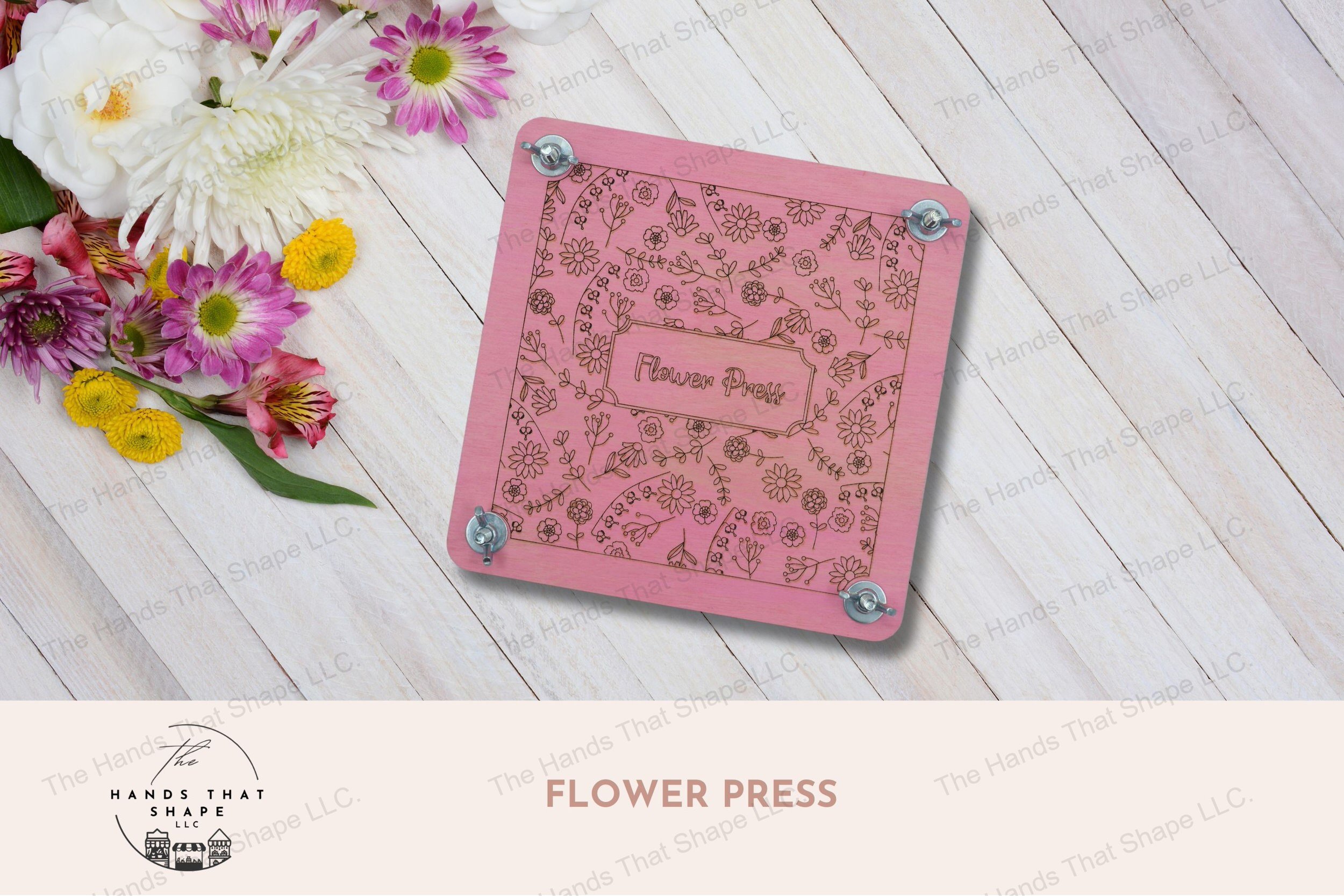 A decorative wooden flower press with laser-marked floral design, complete with cardboard and parchment layers for preserving blooms, pink version.