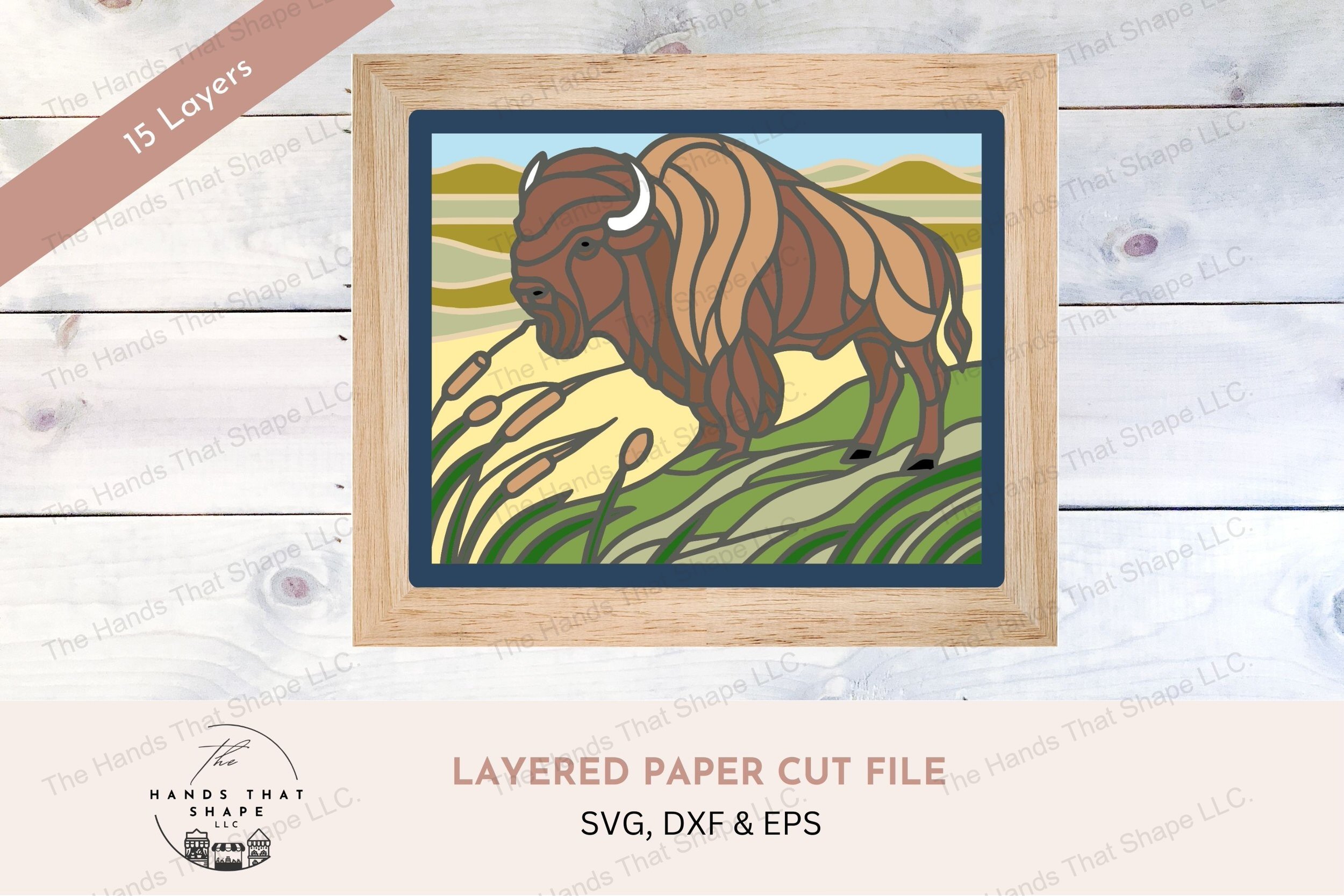 This layered cardstock art piece vividly portrays a majestic bison on the prairie, with rolling hills and windswept grasses, rendered in a stained glass style.