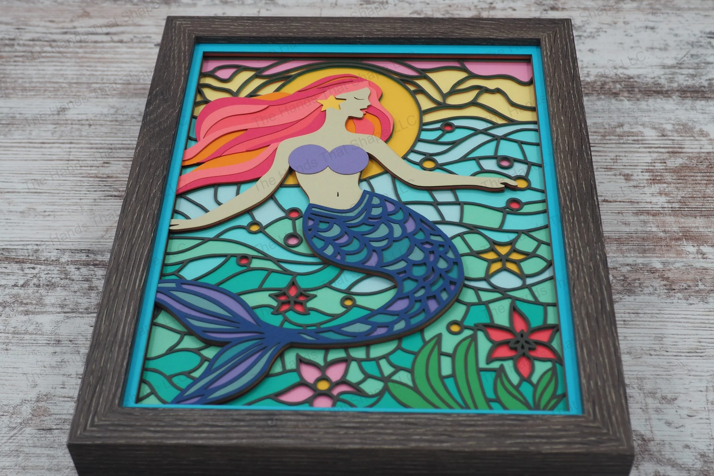 Immerse yourself in the underwater world with this layered paper shadowbox featuring a mermaid with flowing hair, with a stained glass-style backdrop.