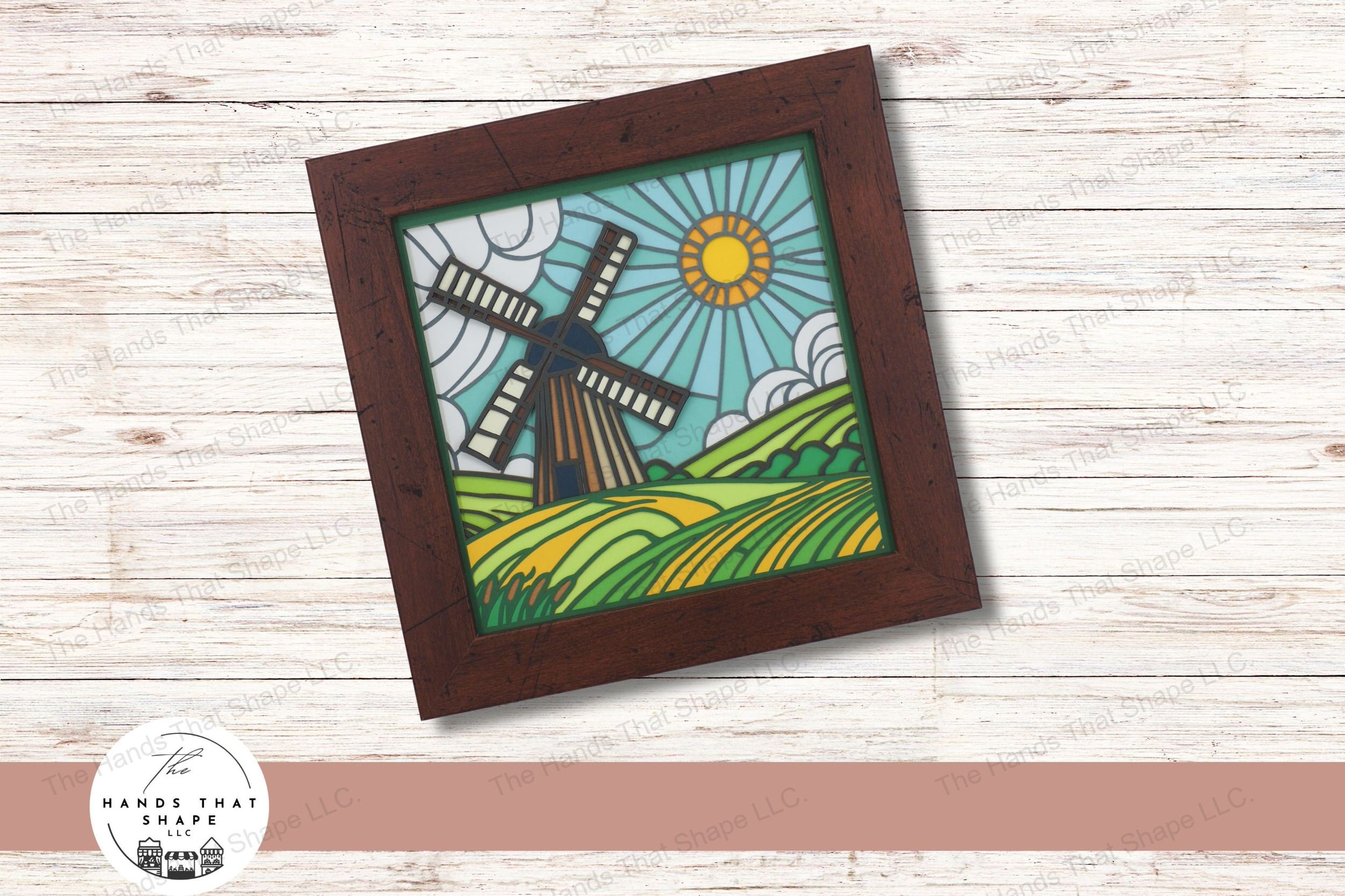 This layered cardstock art piece beautifully depicts an old windmill amidst rolling hills under a sunlit sky evoking the charm of the countryside.