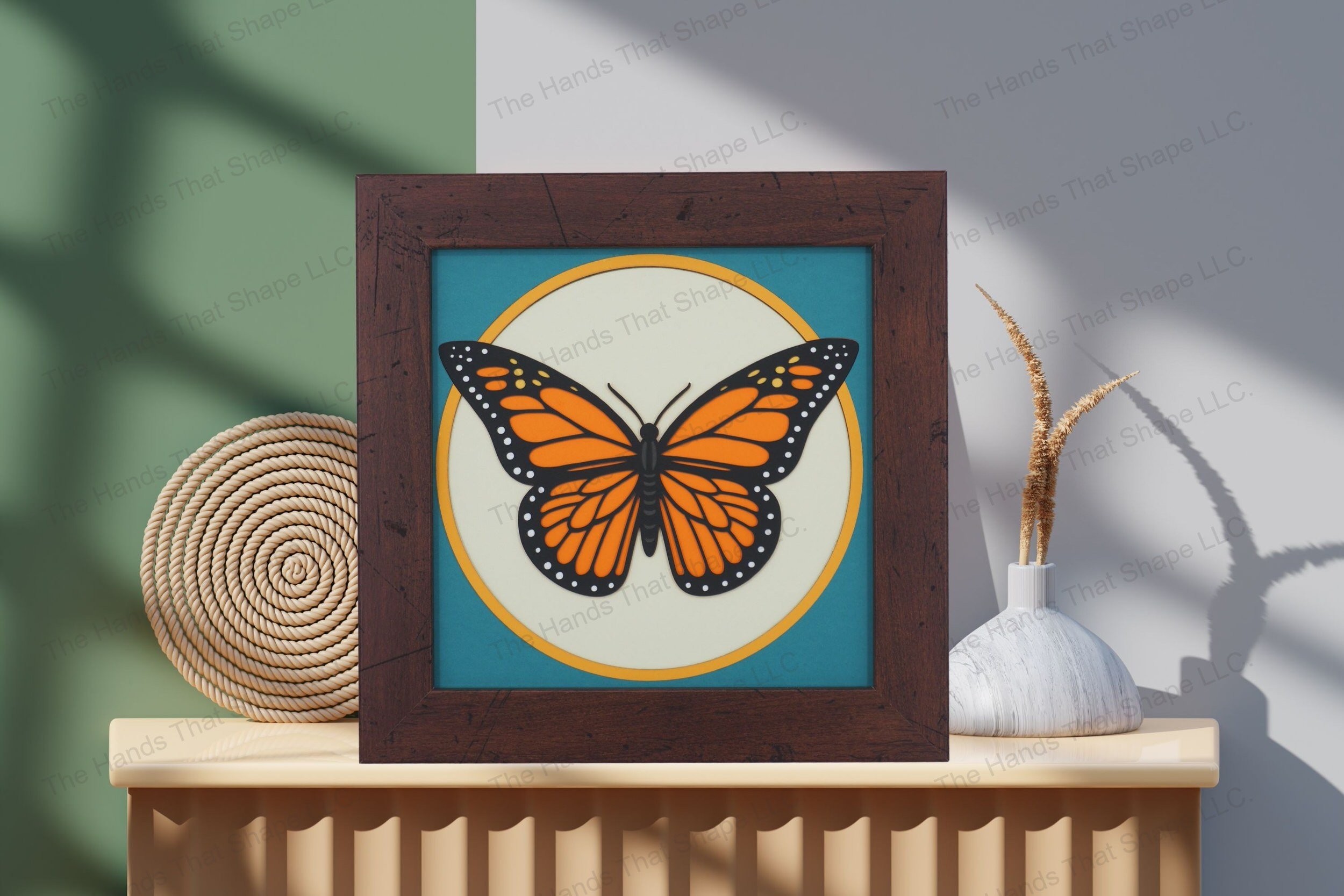 Admire this striking Monarch butterfly-themed cardstock artwork, displayed on a table by a wall, highlighting its vivid colors and multi-layered depth.