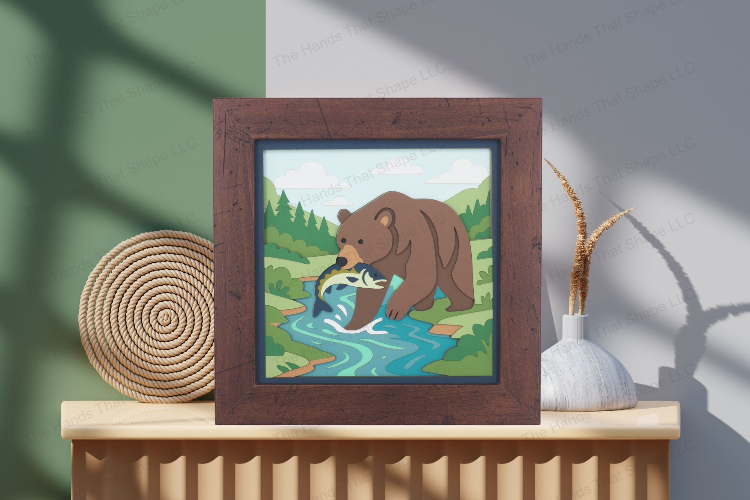 Admire this dramatic bear catching a fish cardstock artwork, thoughtfully displayed on a table, showcasing its rich layering and vivid wilderness detail.