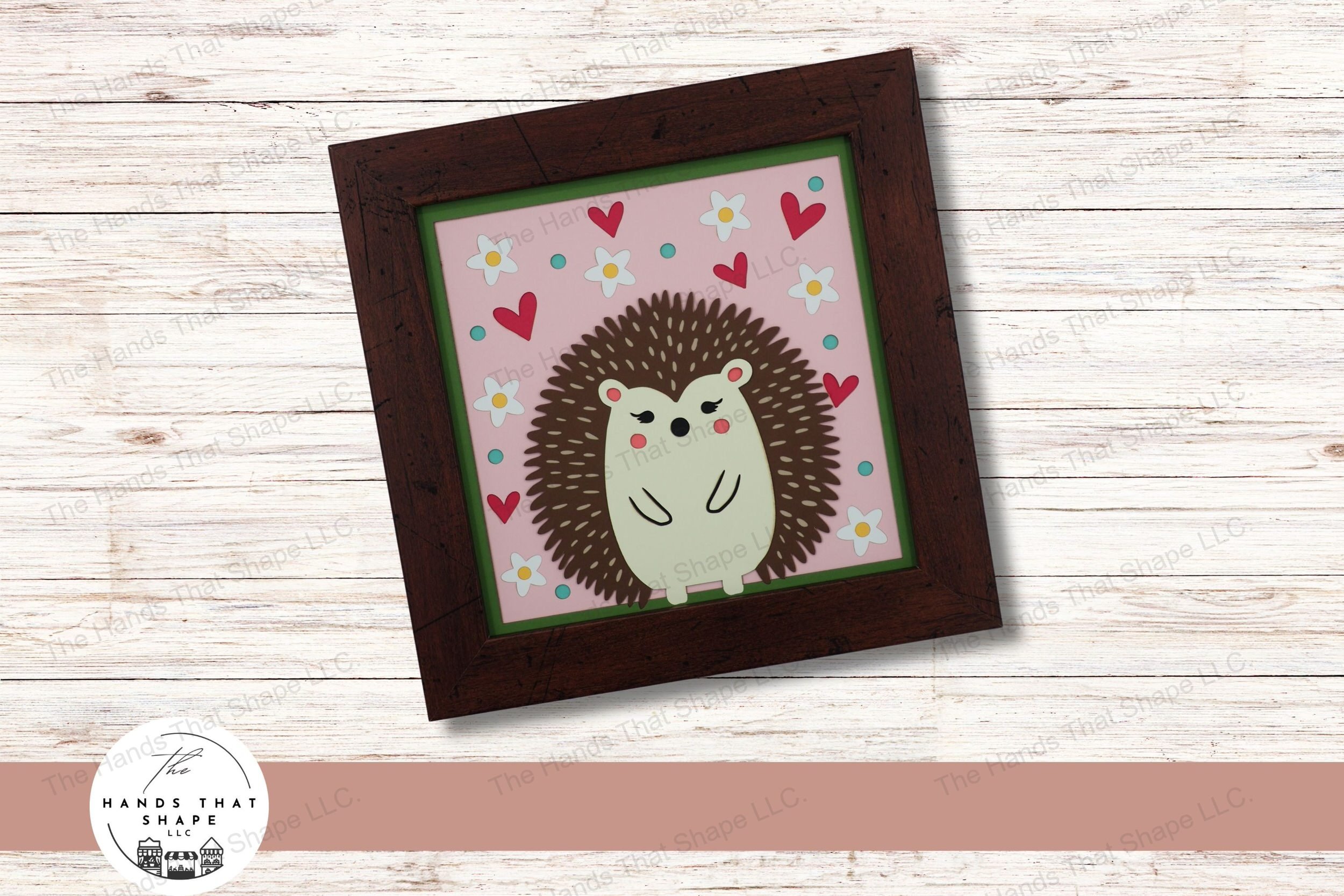 This layered cardstock design features a folksy hedgehog, surrounded by a vibrant array of flowers, dots, and hearts, creating a playful and inviting atmosphere