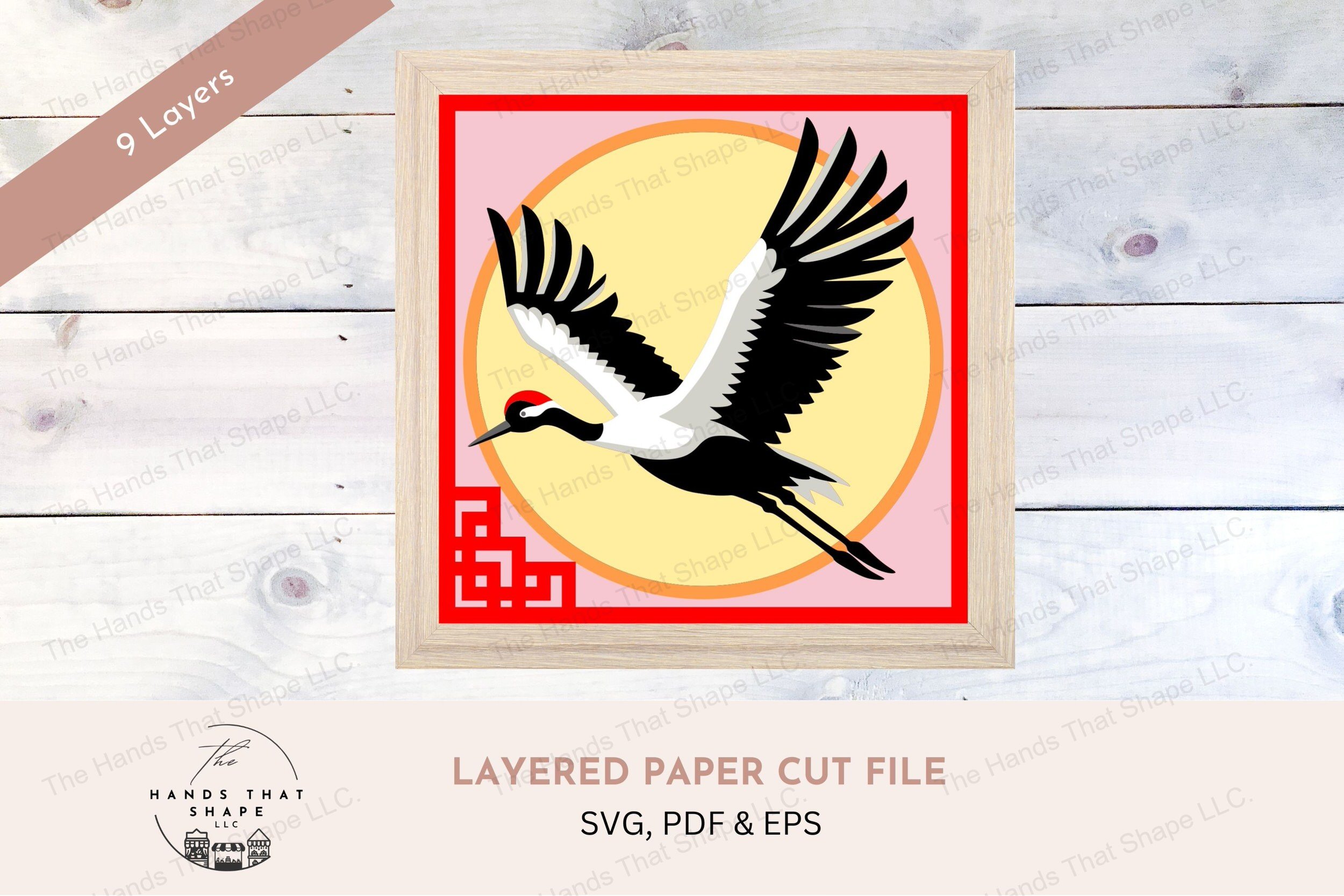 This layered cardstock art piece features a majestic Japanese red-crowned crane soaring through the air with wings fully outstretched.