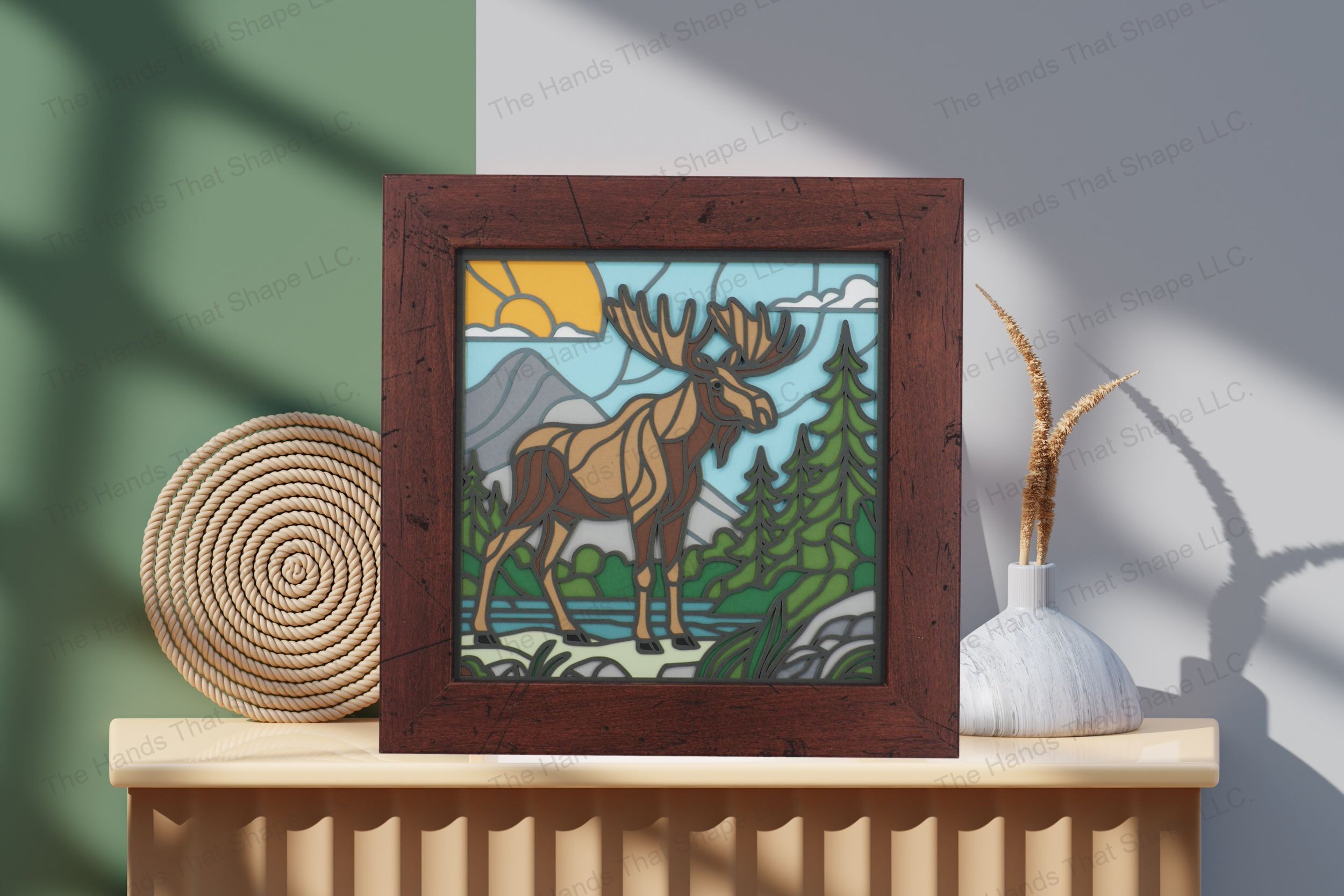 Explore this stunning cardstock artwork of a moose in a watery landscape, artfully displayed on a table, highlighting its rich colors and layered design.