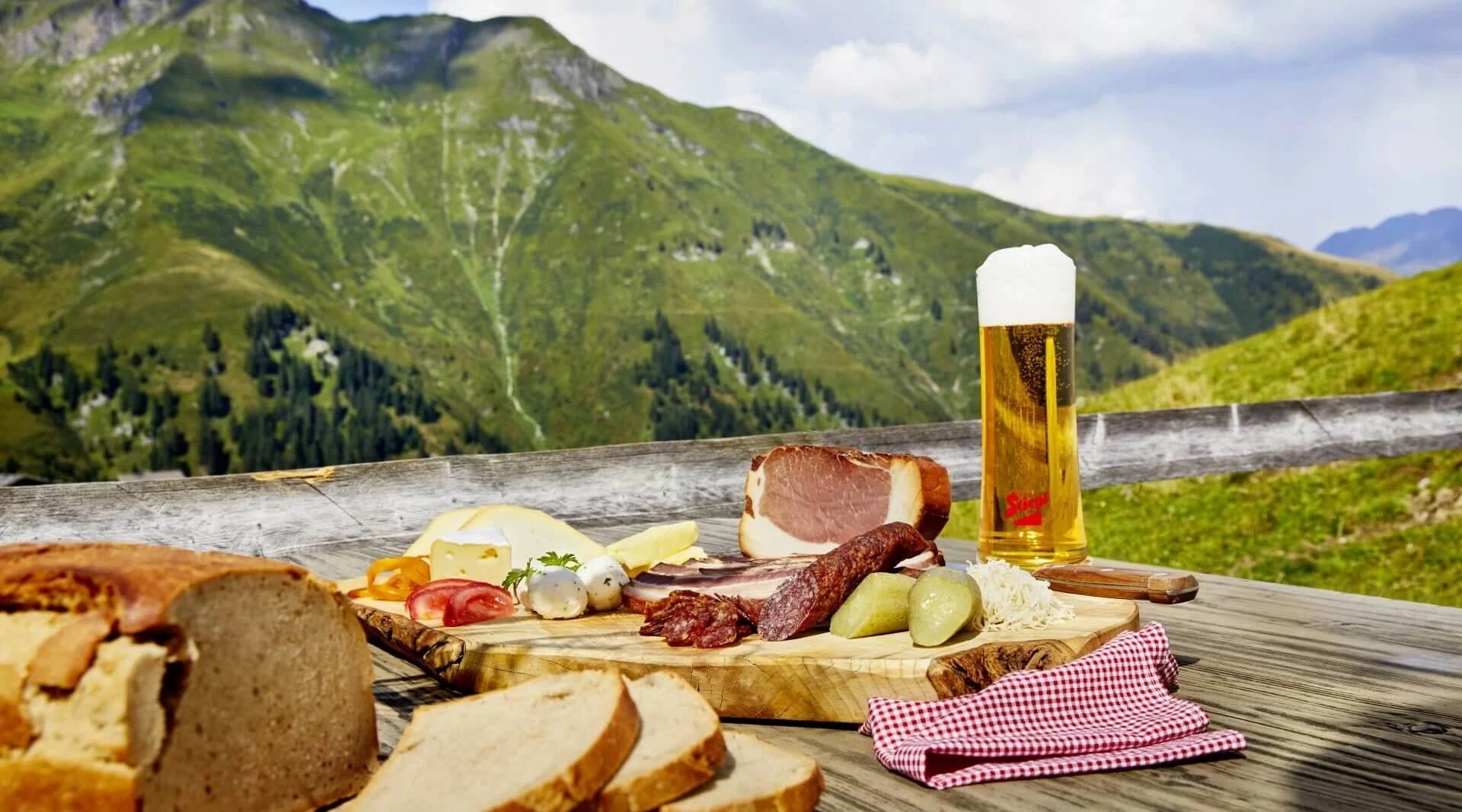 Schneebedeute Berge und Tannenbäume unter klarem blauen Himmel mit scheinender Sonne.