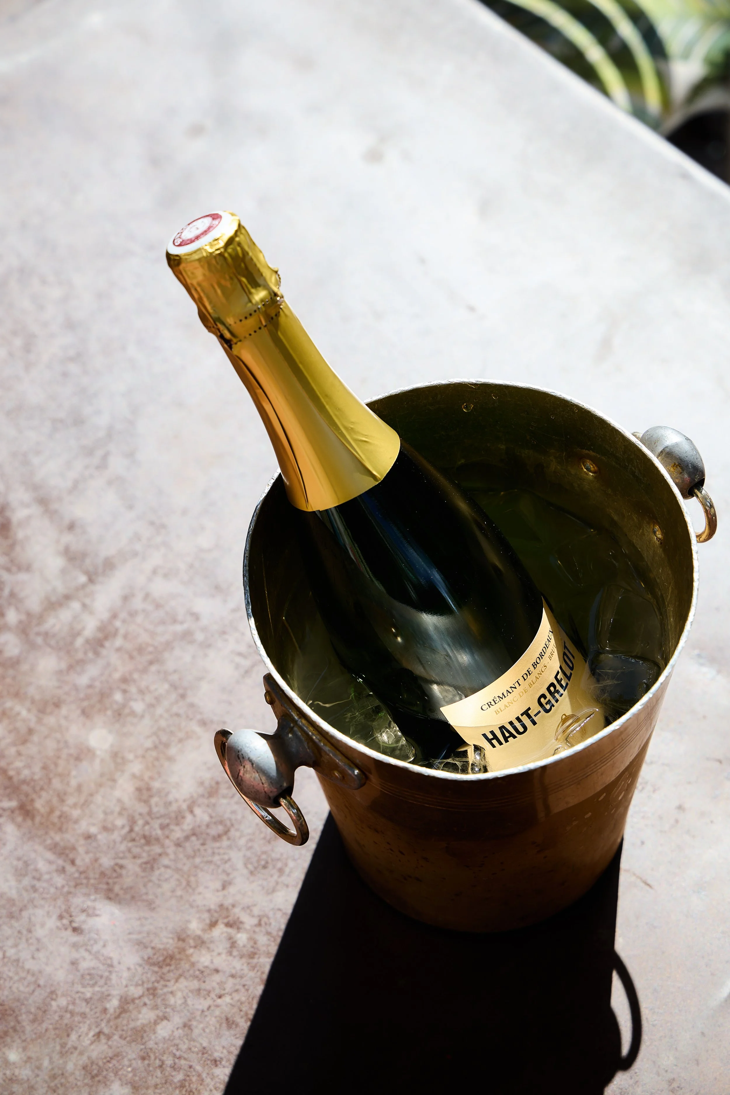 A bottle of sparkling wine chilling in an ice bucket.
