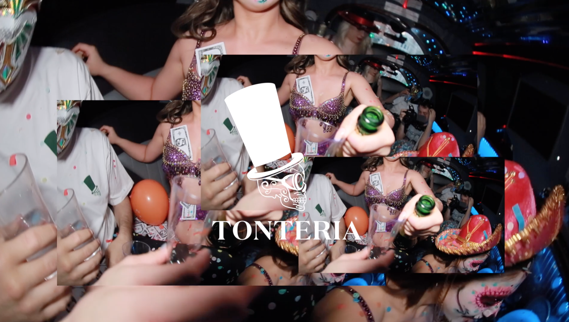 People celebrating at a party with balloons, drinks, and decorations. A woman in a sparkly top and a woman wearing a sombrero are visible.