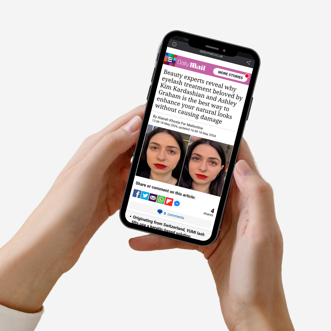 Person holding a smartphone displaying a Daily Mail news article with images of a woman before and after a YUMI Keratin Lash Lift.
