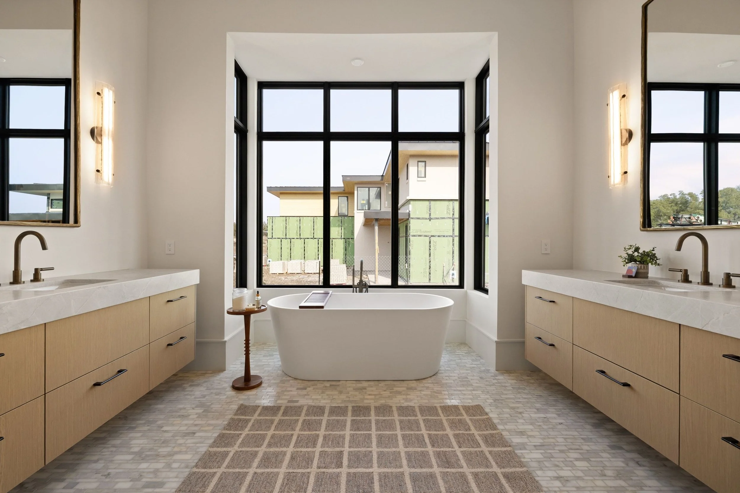 Primary bathroom with freestanding tub, wood vanity, and natural stone finishes