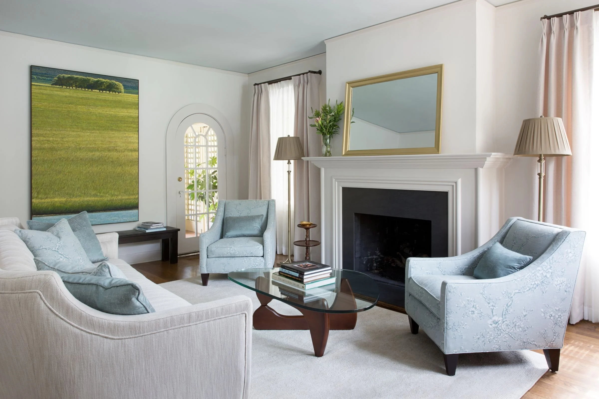 Living room with fireplace, armchairs, and glass coffee table