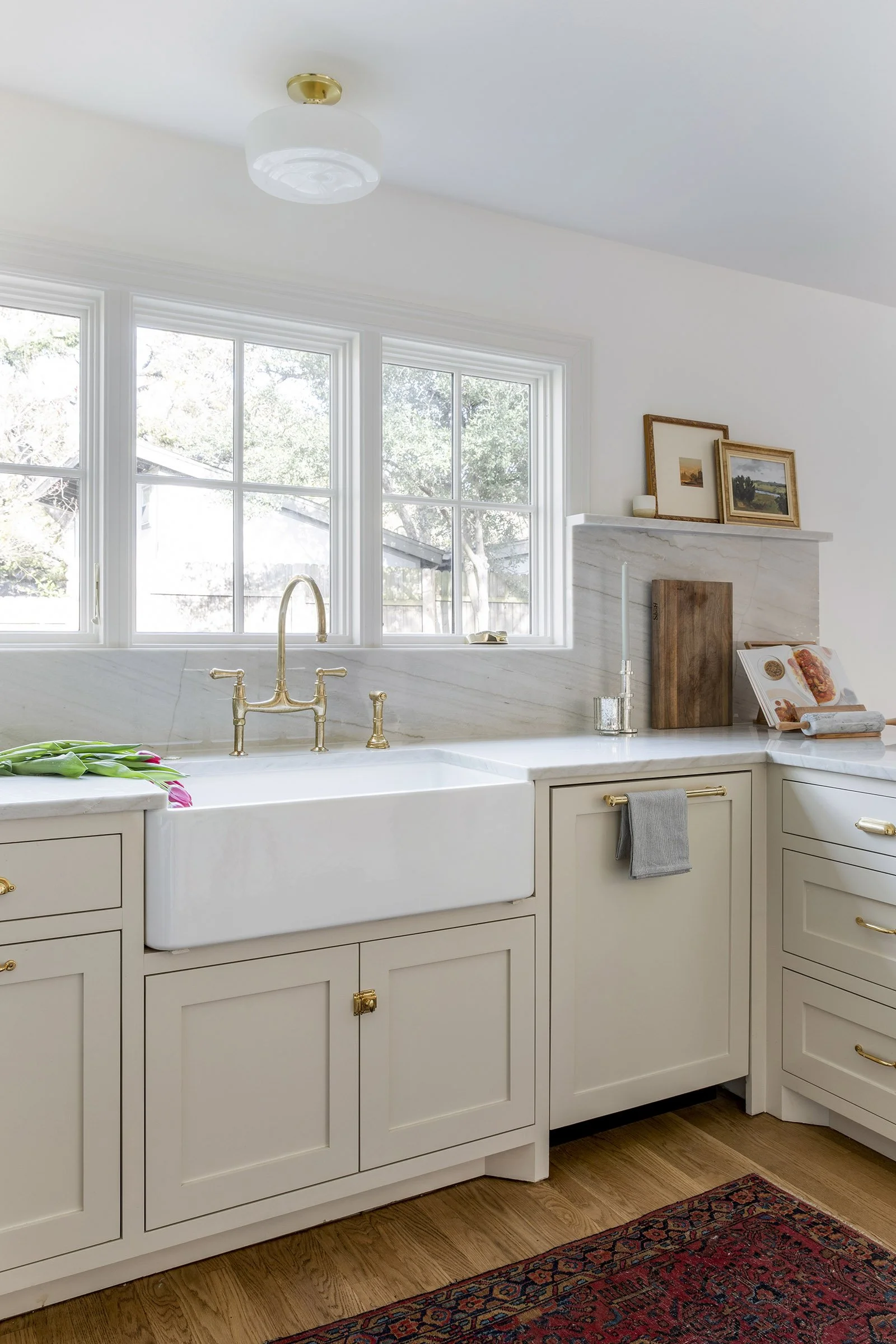 Kitchen with farmhouse sink, brass faucet, and marble backsplash design