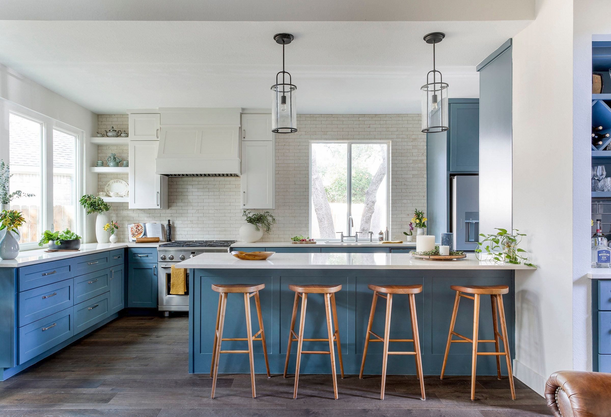 Kitchen with blue island, bar stools, and pendant lighting design