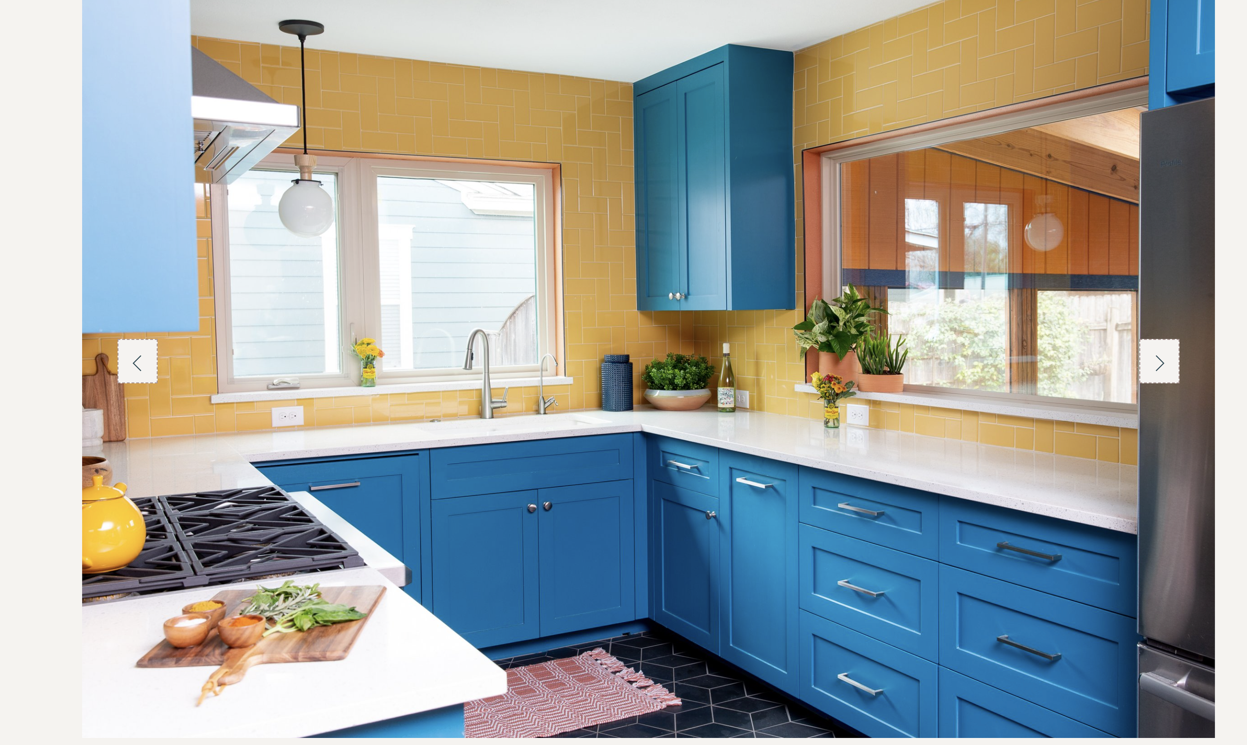 Kitchen with blue cabinetry, yellow tile backsplash, and modern design