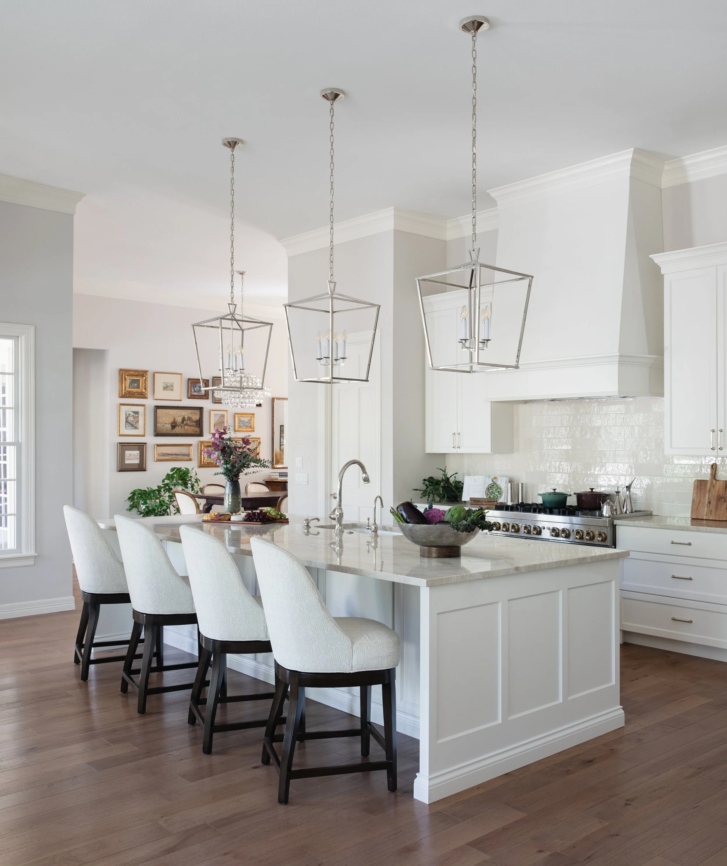 Kitchen with large island, white cabinetry, and pendant lighting design
