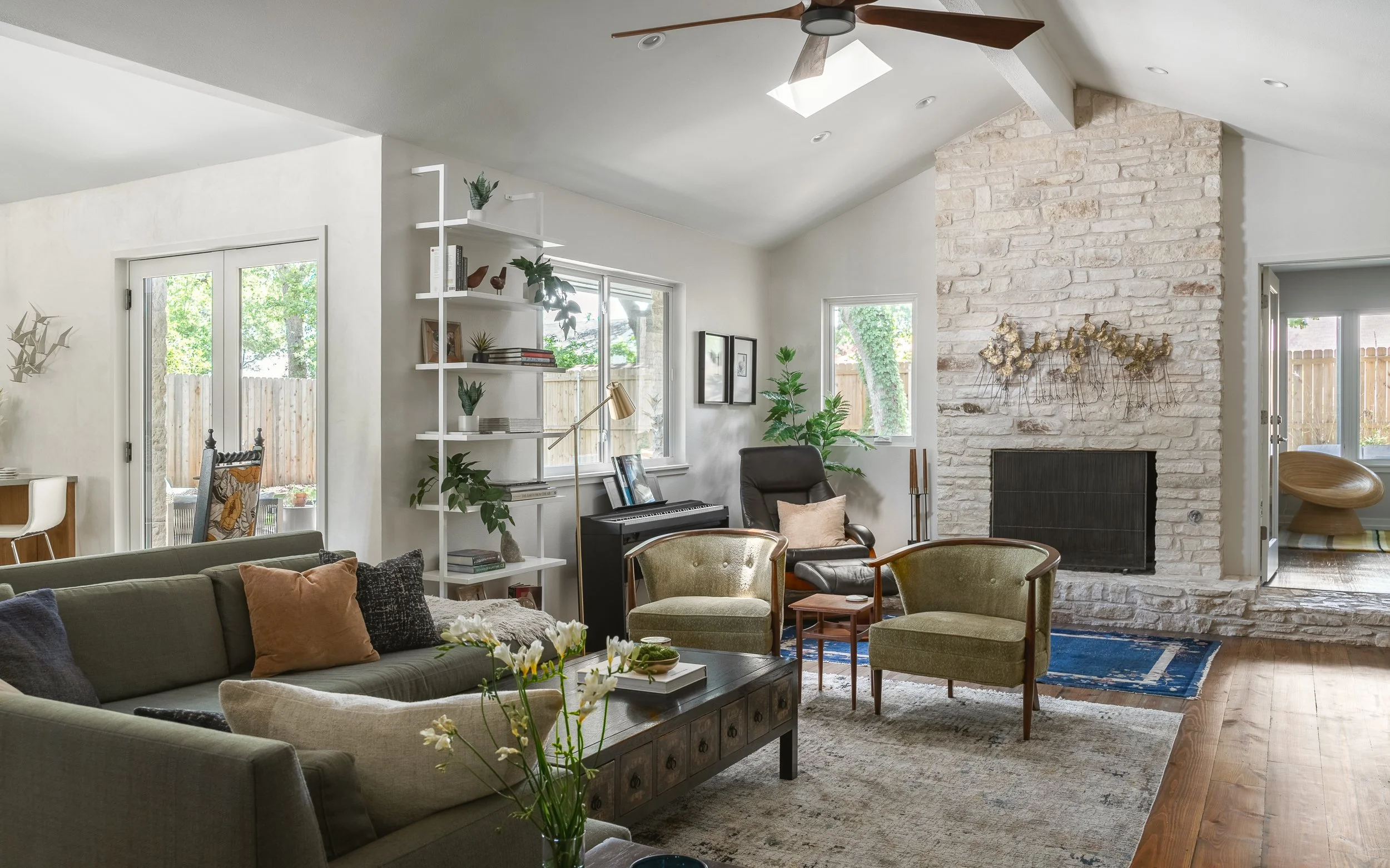 Living room with vaulted ceiling, stone fireplace, and modern seating design