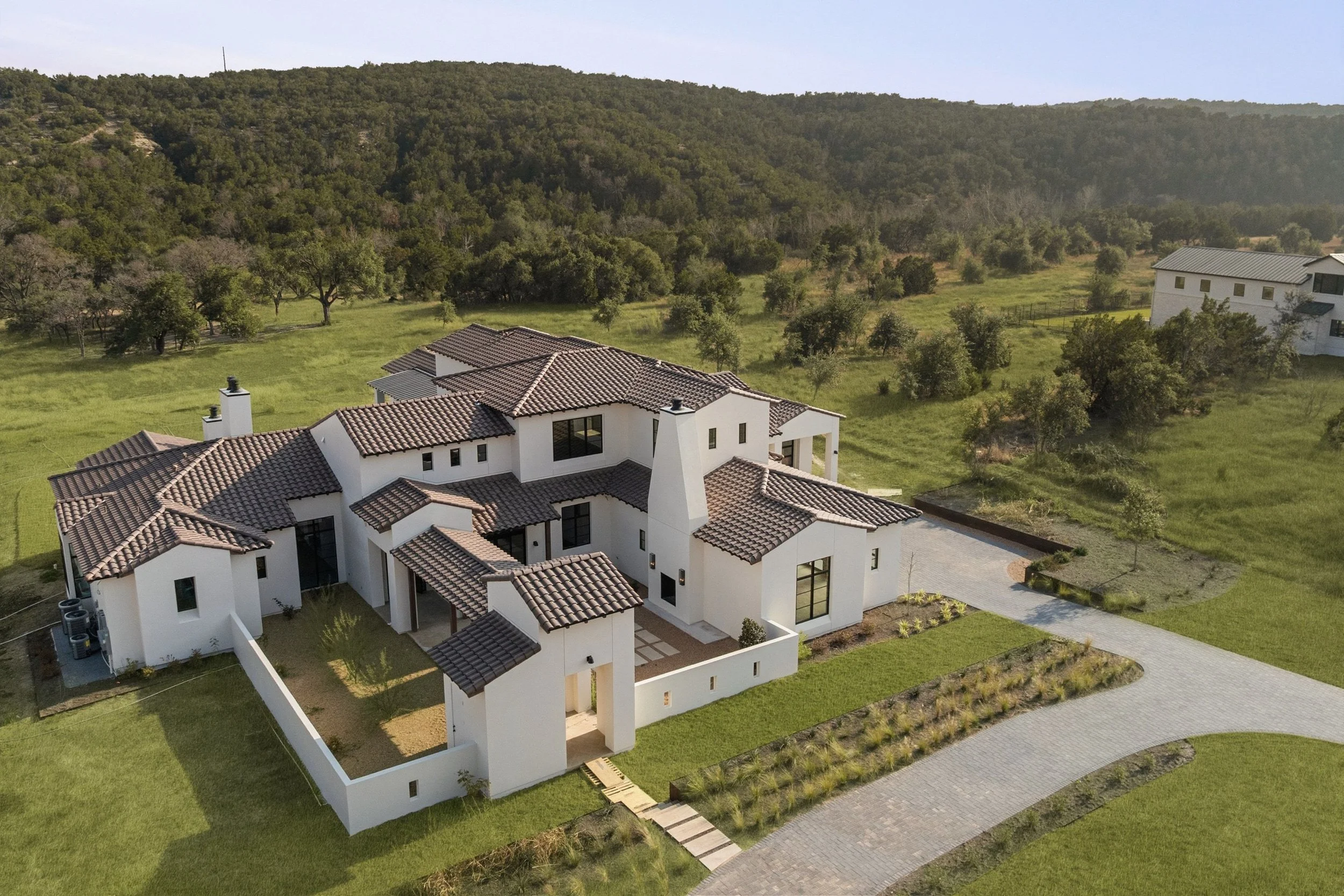 Aerial property view showcasing luxury home and surrounding Hill Country landscape