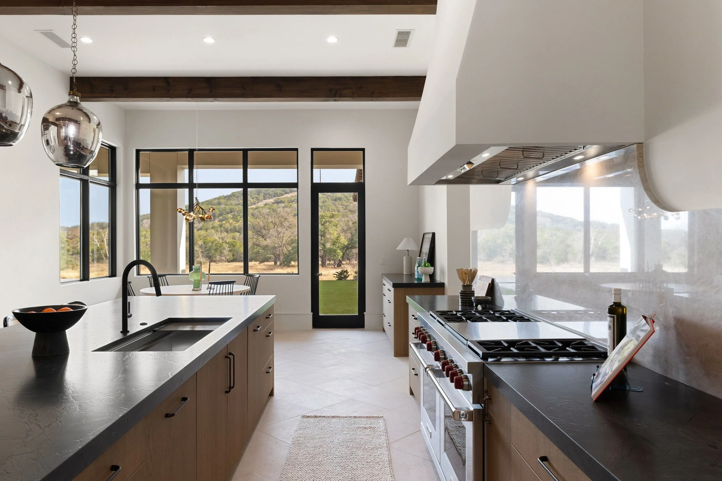 Professional range with plaster hood and marble backsplash in luxury kitchen
