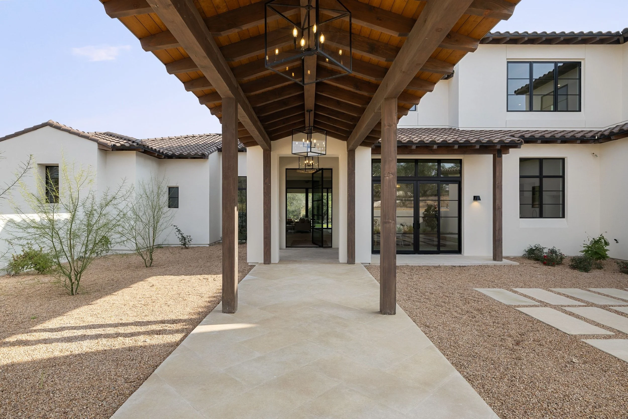 Dramatic covered entryway extends from the exterior vestibule through the walled garden to the front door.