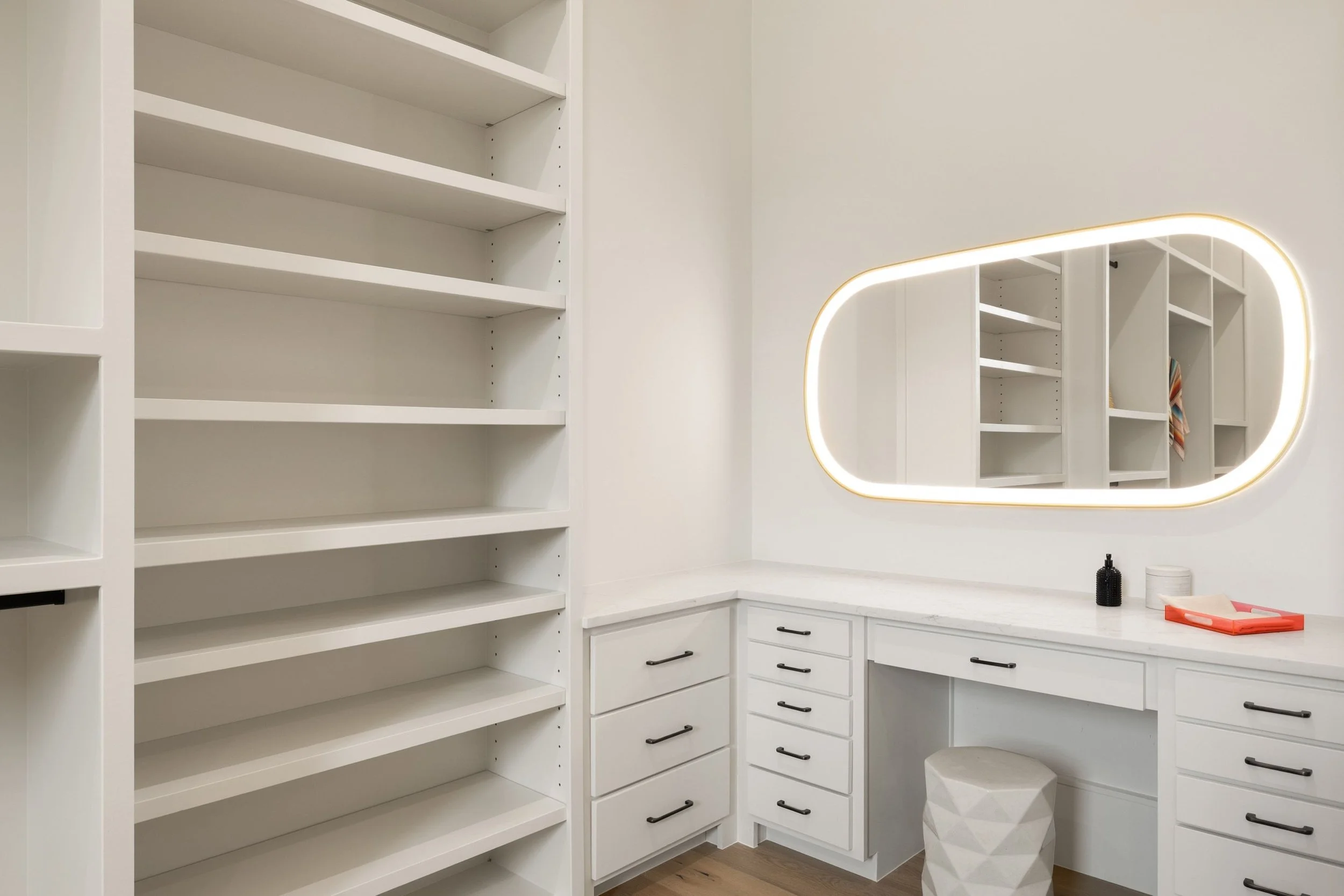 Primary bedroom walk-in closet and vanity and shelving