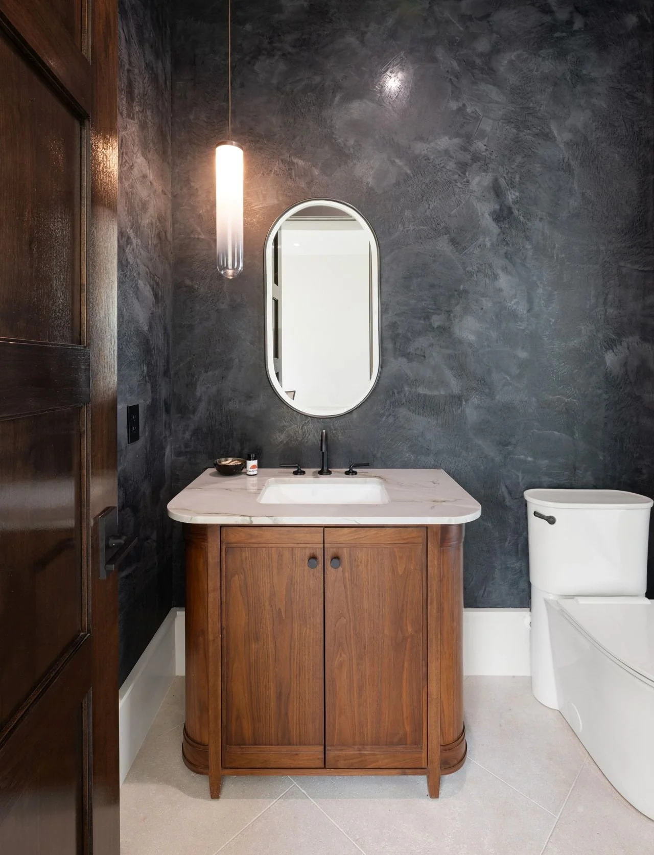 Bathroom design with dark walls, oval mirror, wooden vanity