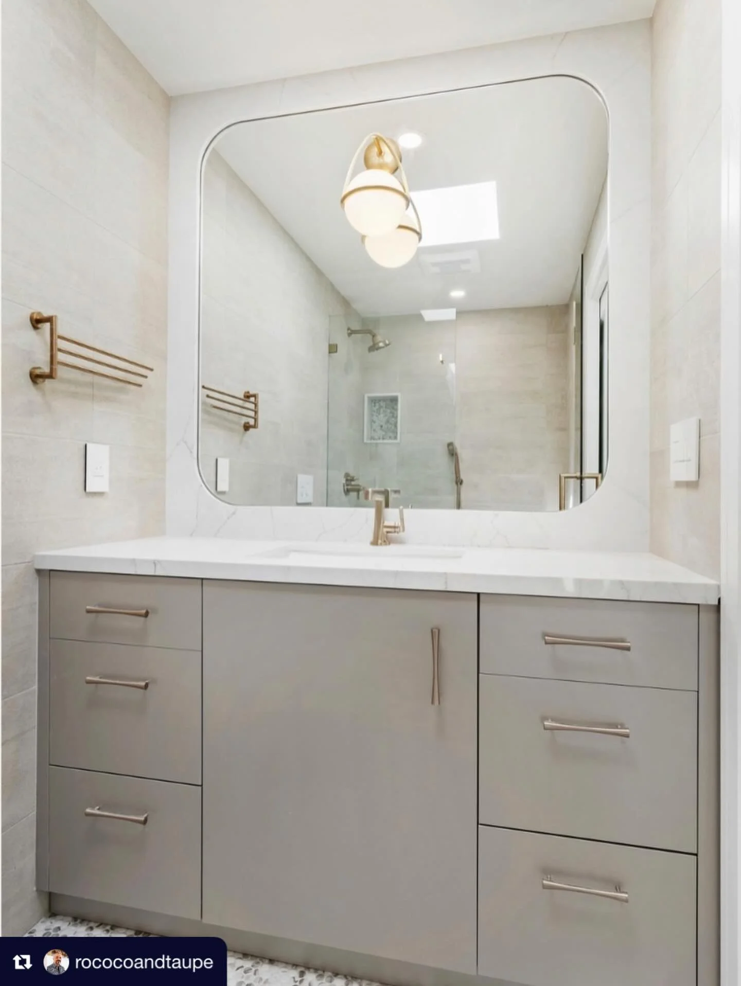 Repost from @rococoandtaupe
&bull;
Simple details make this ADU bathroom a modern retreat that is also easy to care for and maintain. @primary_kitchen matte champagne laminate cabinets, @vadaraquartz slab and @brizofaucet in their Luxe Gold finish ad