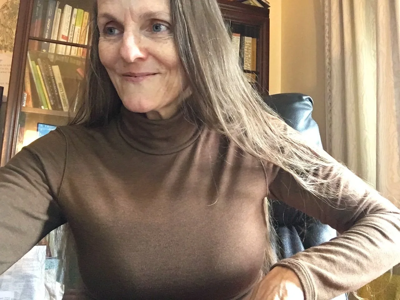 Image of author Sunny Peace smiling at her desk.
