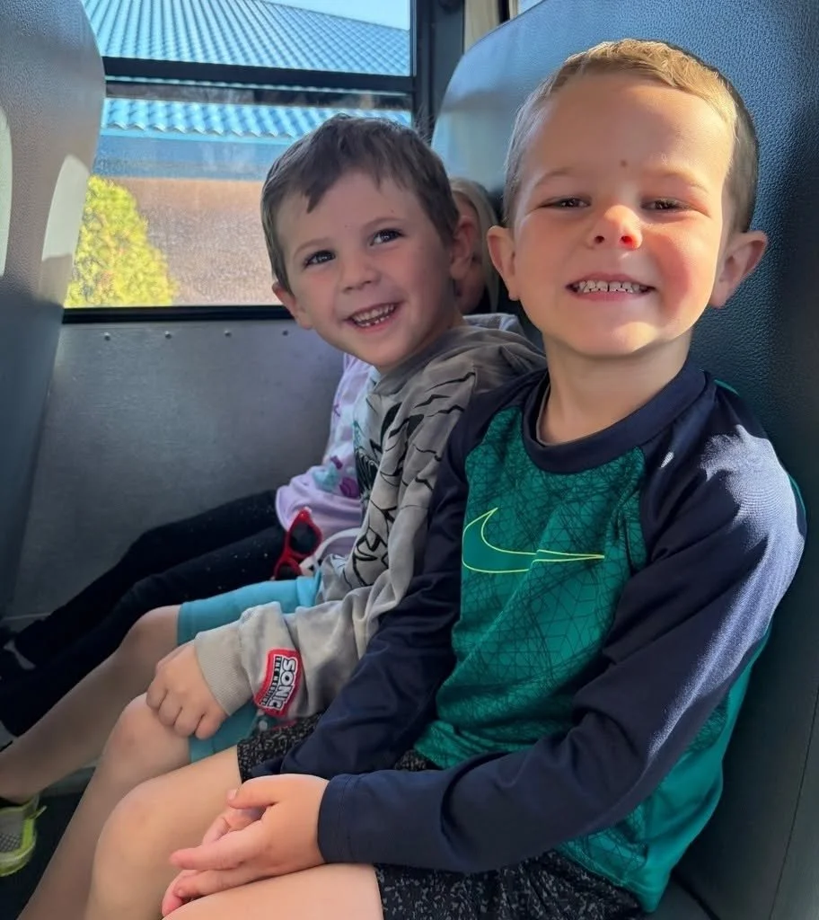 Two young students in bus smiling