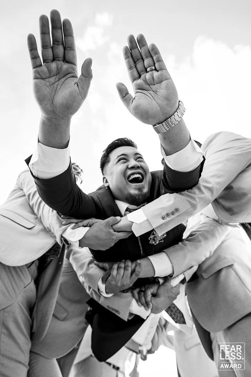 Fearless Photographers Award Winning photo of groom being tossed in the air by his groomsmen 
