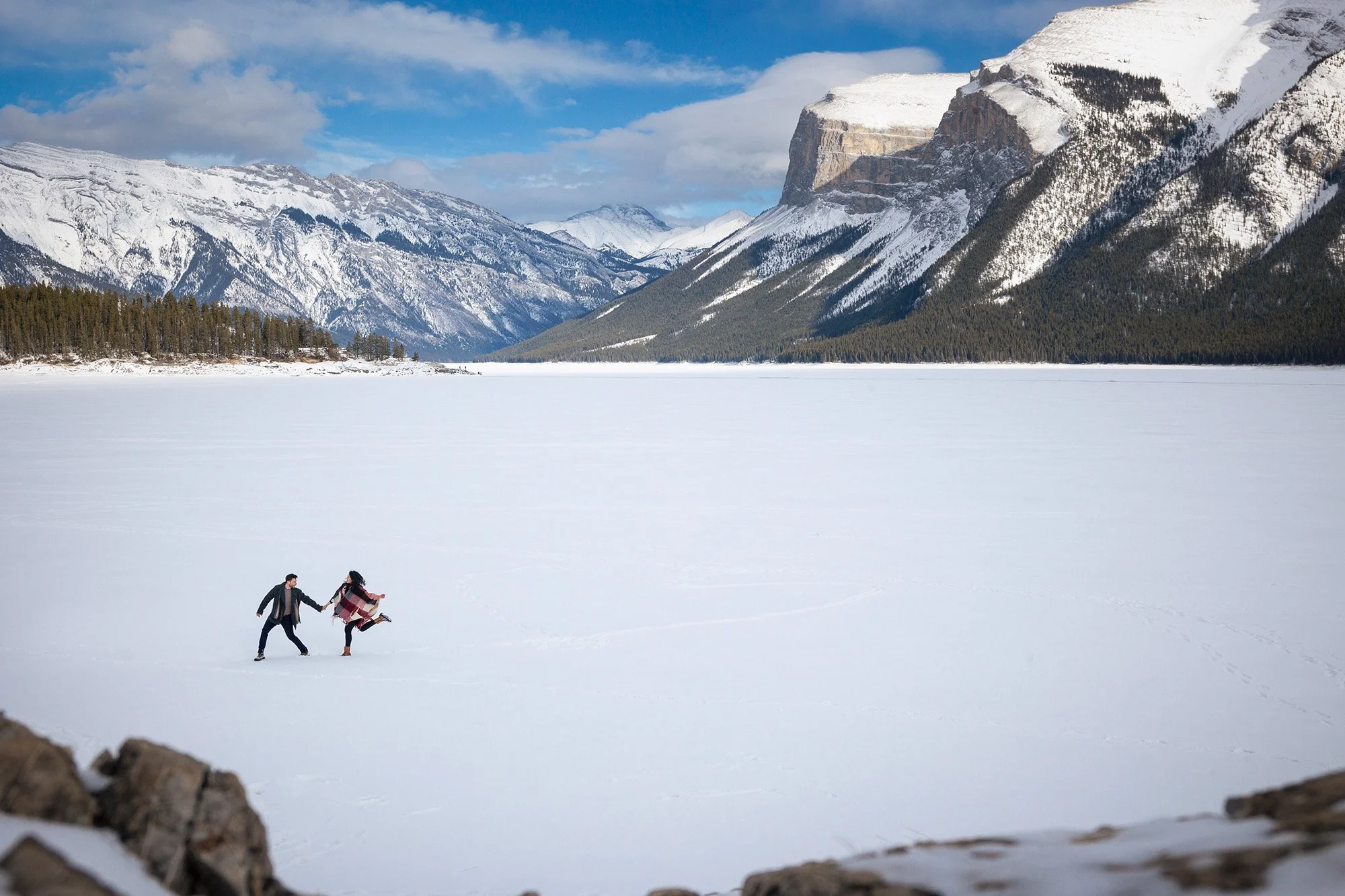 Couples leaps across snowy frozen Lake Minnewanka
