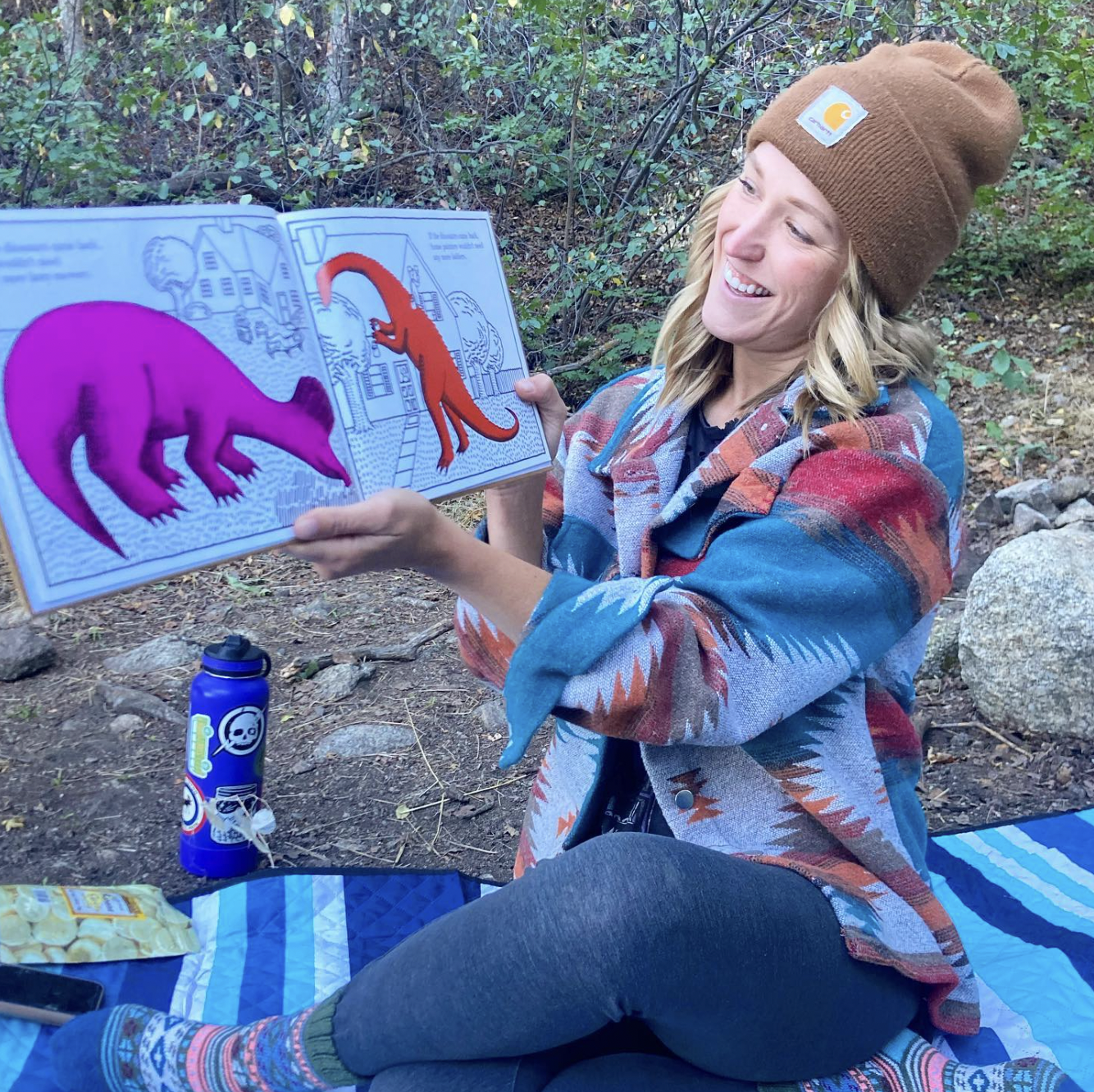 Director Mackenzy Johnson reading a book. Outdoor nature school in salt lake valley Utah.