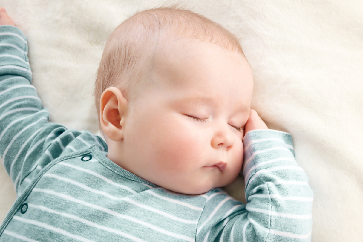 Baby sleeping peacefully in a cot during the night