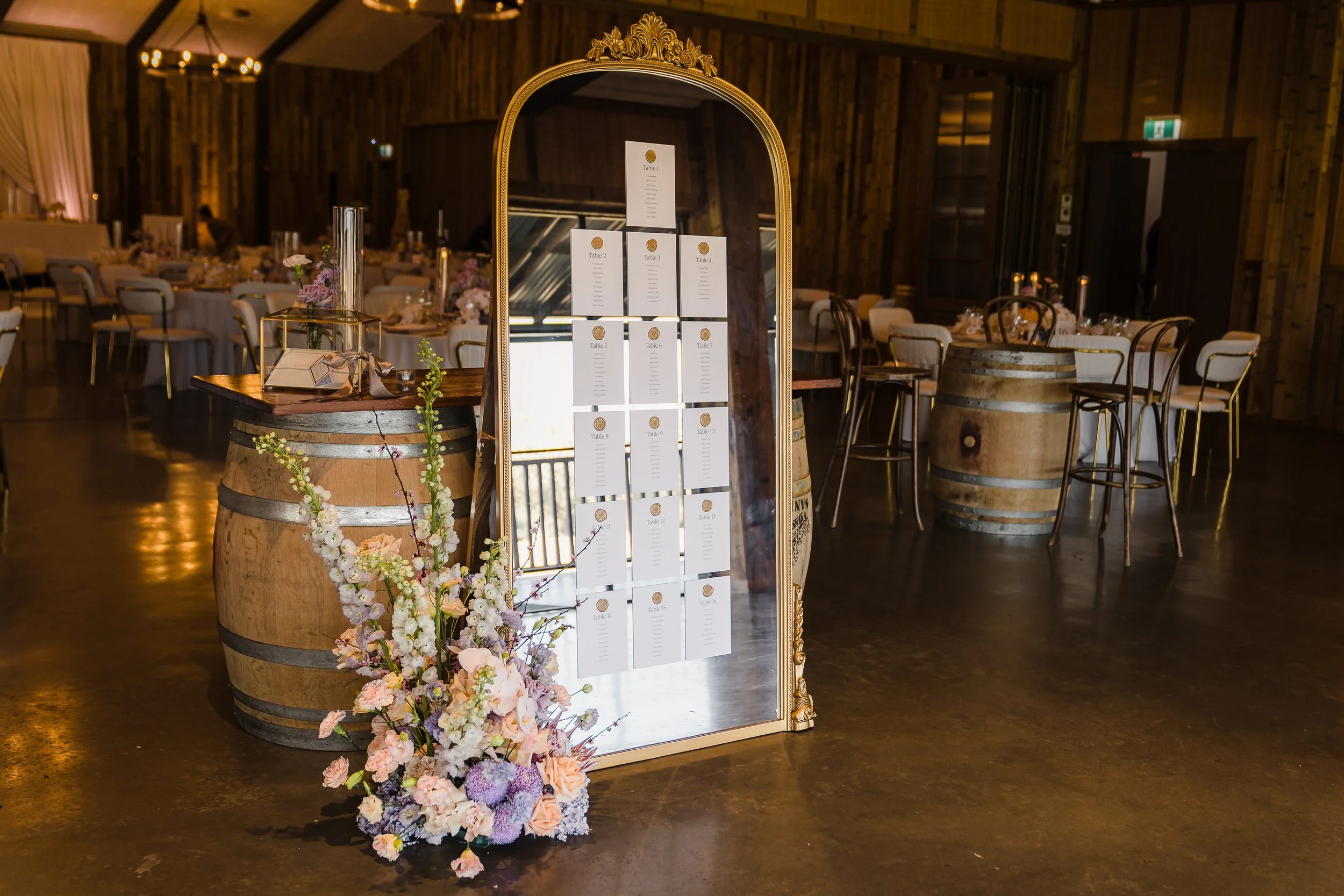 Vintage, gold mirror wedding seating chart with pastel floral arrangement