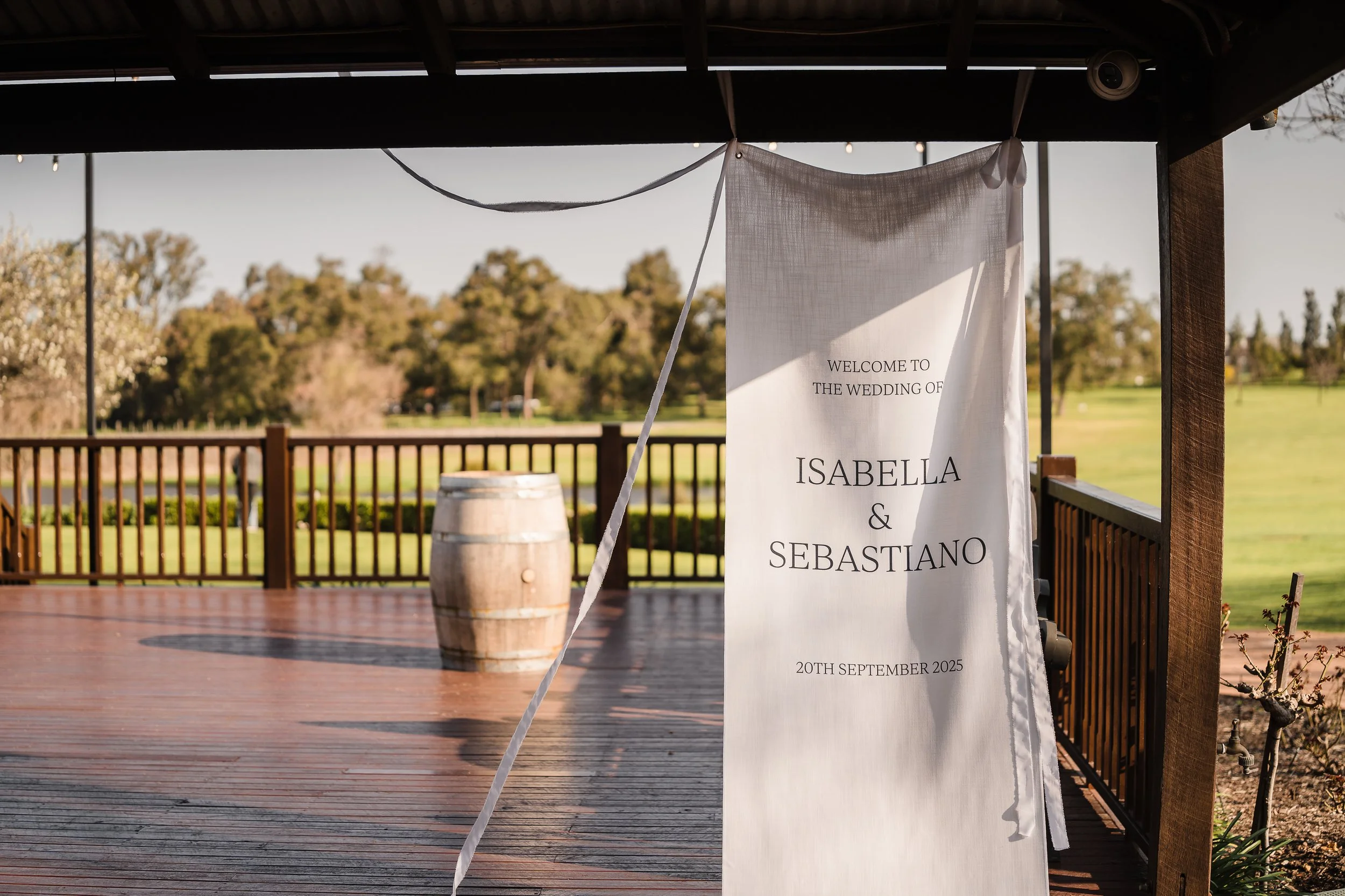 White linen wedding welcome sign hanging from a rafter on the Deck at Sandalford Winery, Swan Valley