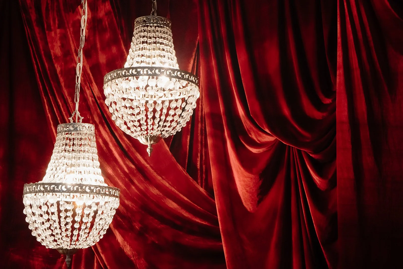 Ceremony backdrop in Nikola Estate’s Moondyne Joe Room featuring, rich red velvet draping and hanging crystal chandeliers.
