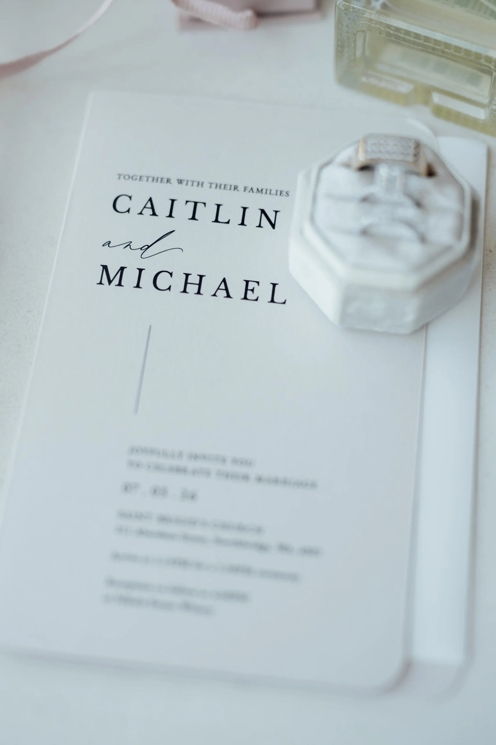 Modern black and white wedding invitation with wedding bands in ring box.