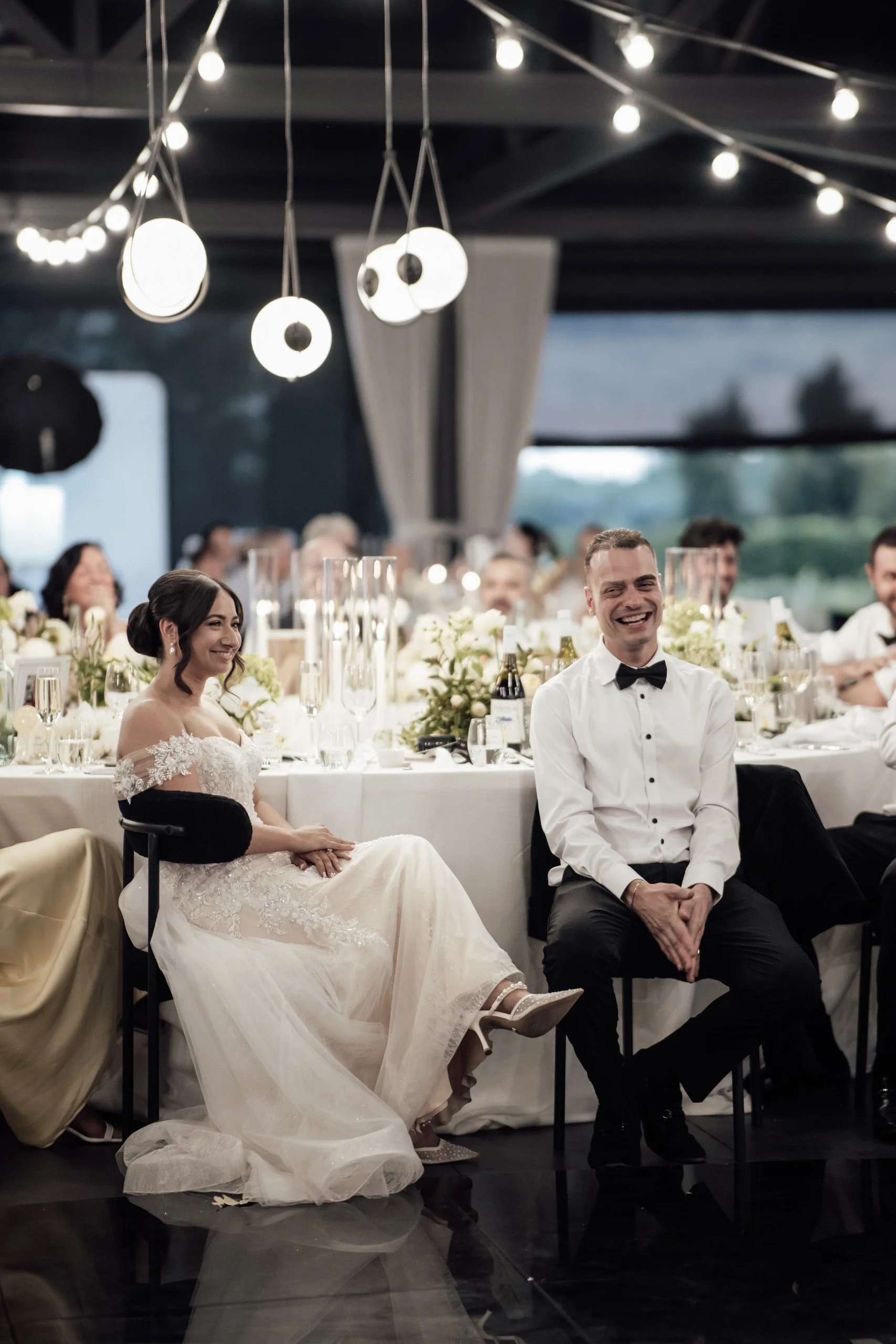 Bride and groom seated at the circular feature bridal table during their wedding reception.