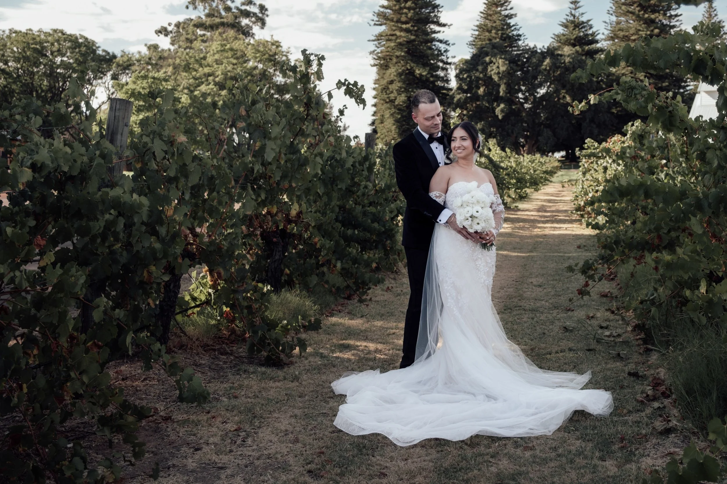 Newlyweds sharing a quiet moment among the Nikola Estate vineyards after their wedding ceremony.