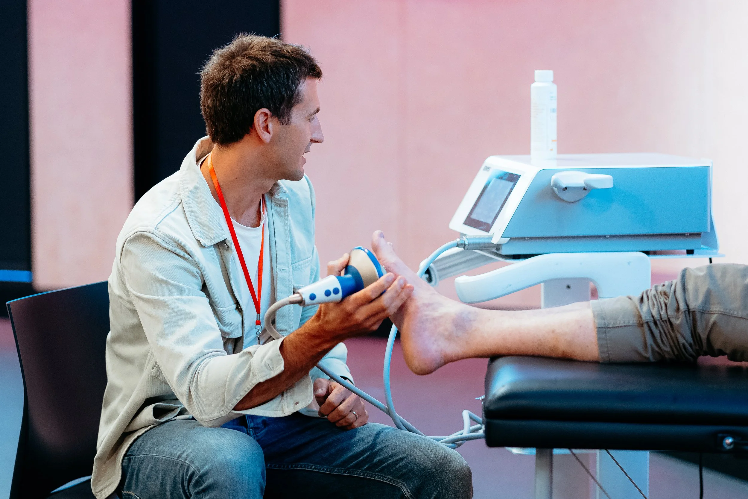 Medical professional performing an ultrasound on a patient's foot in a clinical setting.