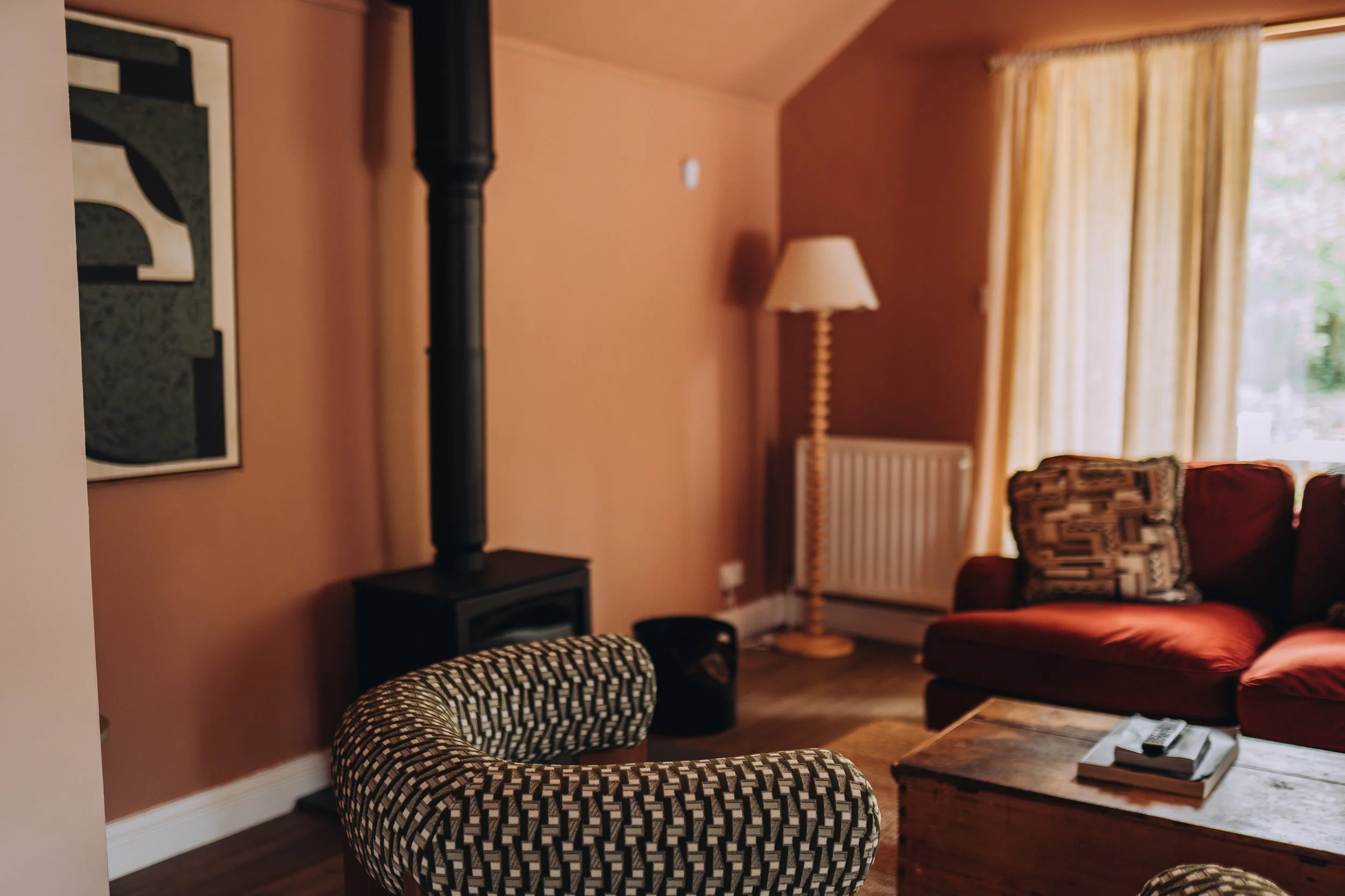 Terracotta living room with wood burner at Church Farm Estate