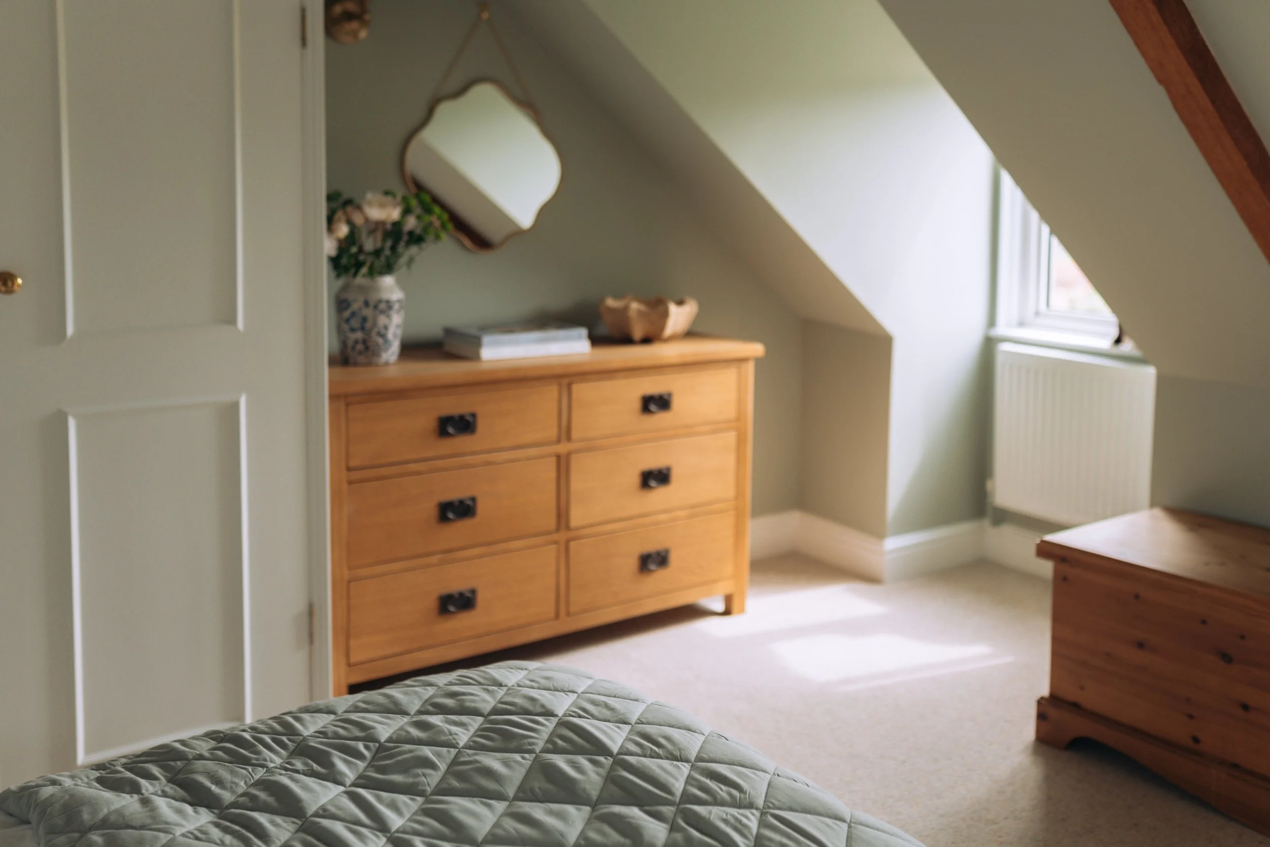 Attic bedroom with oak chest of drawers at Moon End Cottage, Somerset