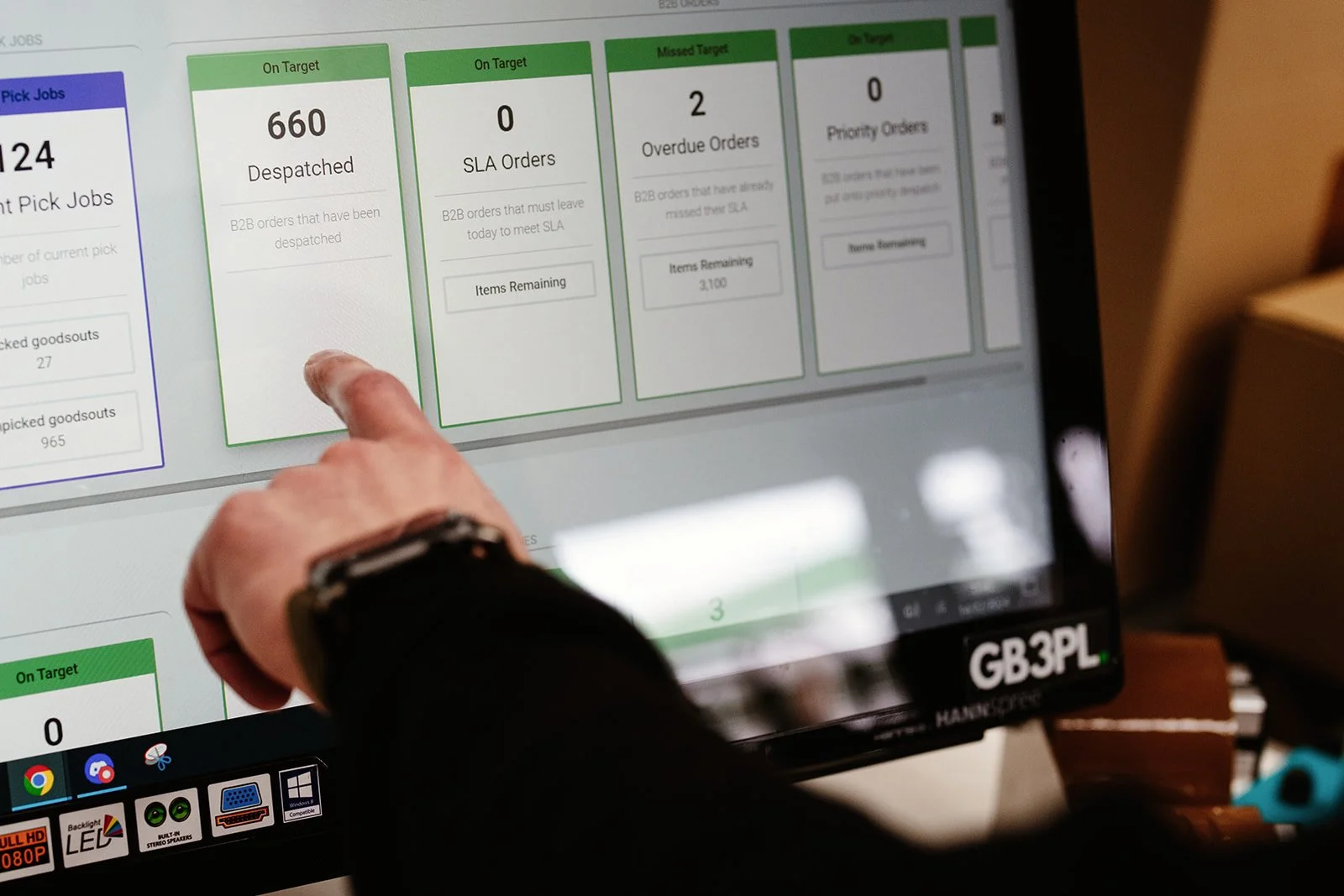 A finger points to a logistics CRM at an e-commerce fulfilment warehouse in Norwich.