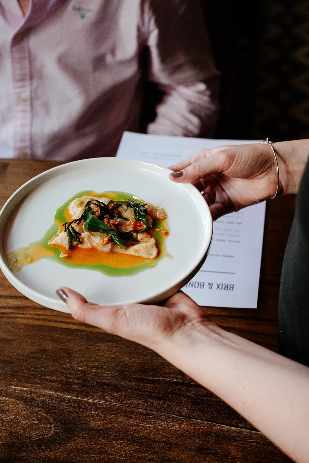 A starter plate shown in close up detail being delivered to a table at Brix and Bones, Norwich.