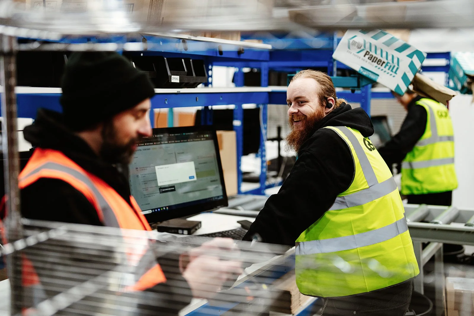 Staff members smiling and chatting as they go about their work at an e-commerce fulfilment warehouse in Norwich.