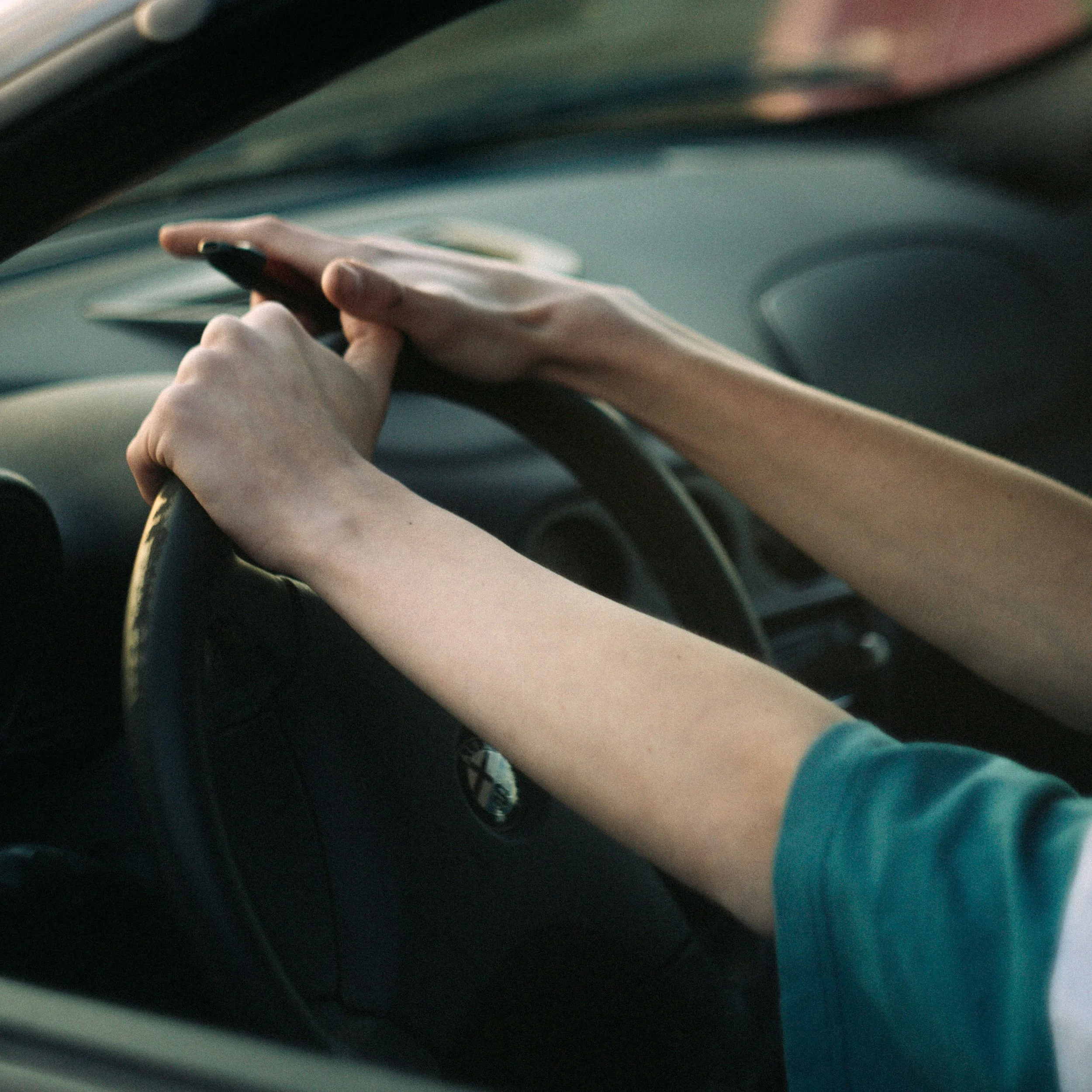 Hands on a steering wheel indicating a turn