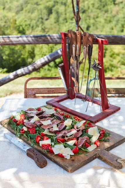 At the Table of La Fortezza: Grilled steak with Arugula, Fresh Tomatoes, and Shaved Parmesan 