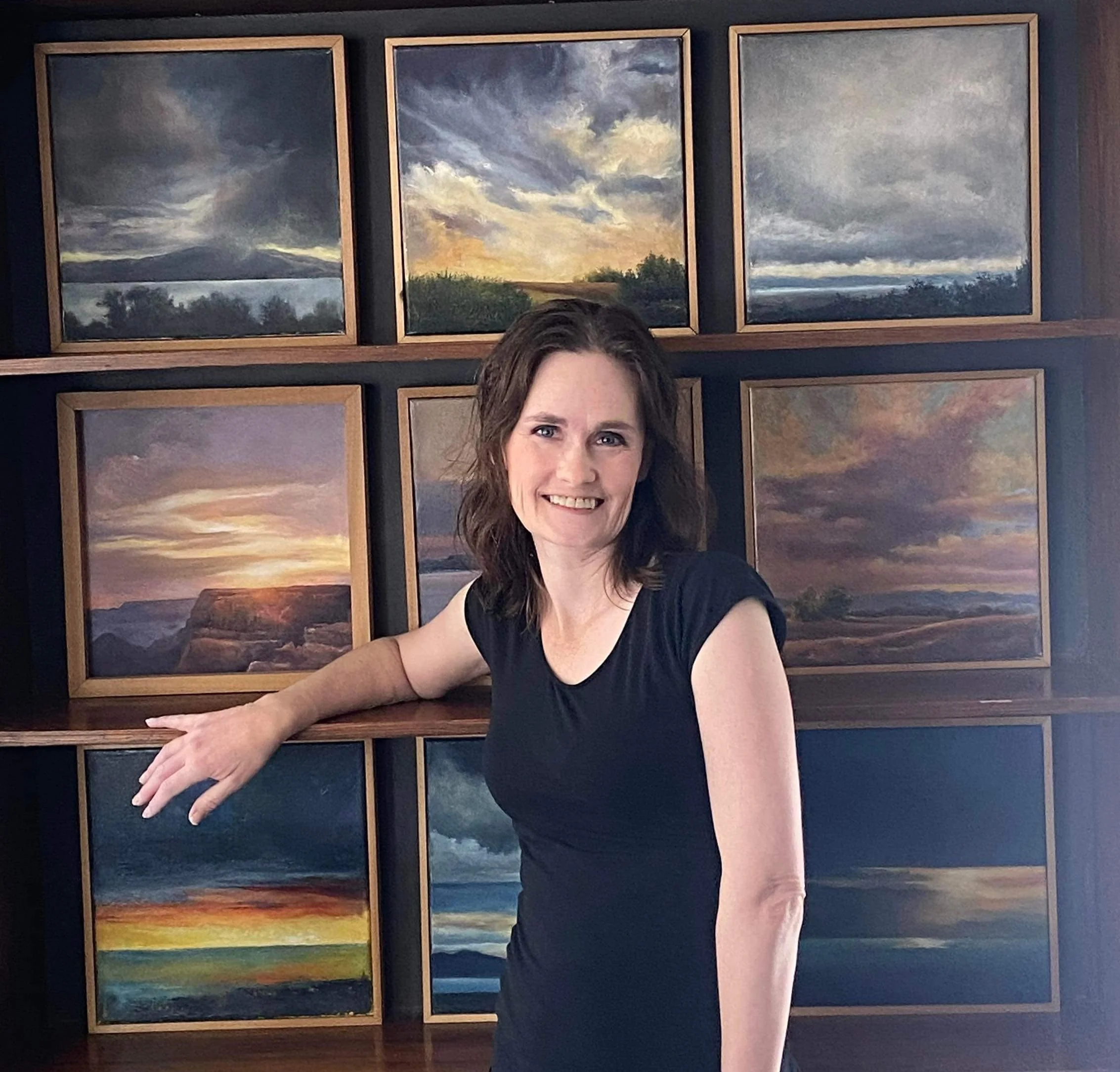 Woman smiling in front of green foliage